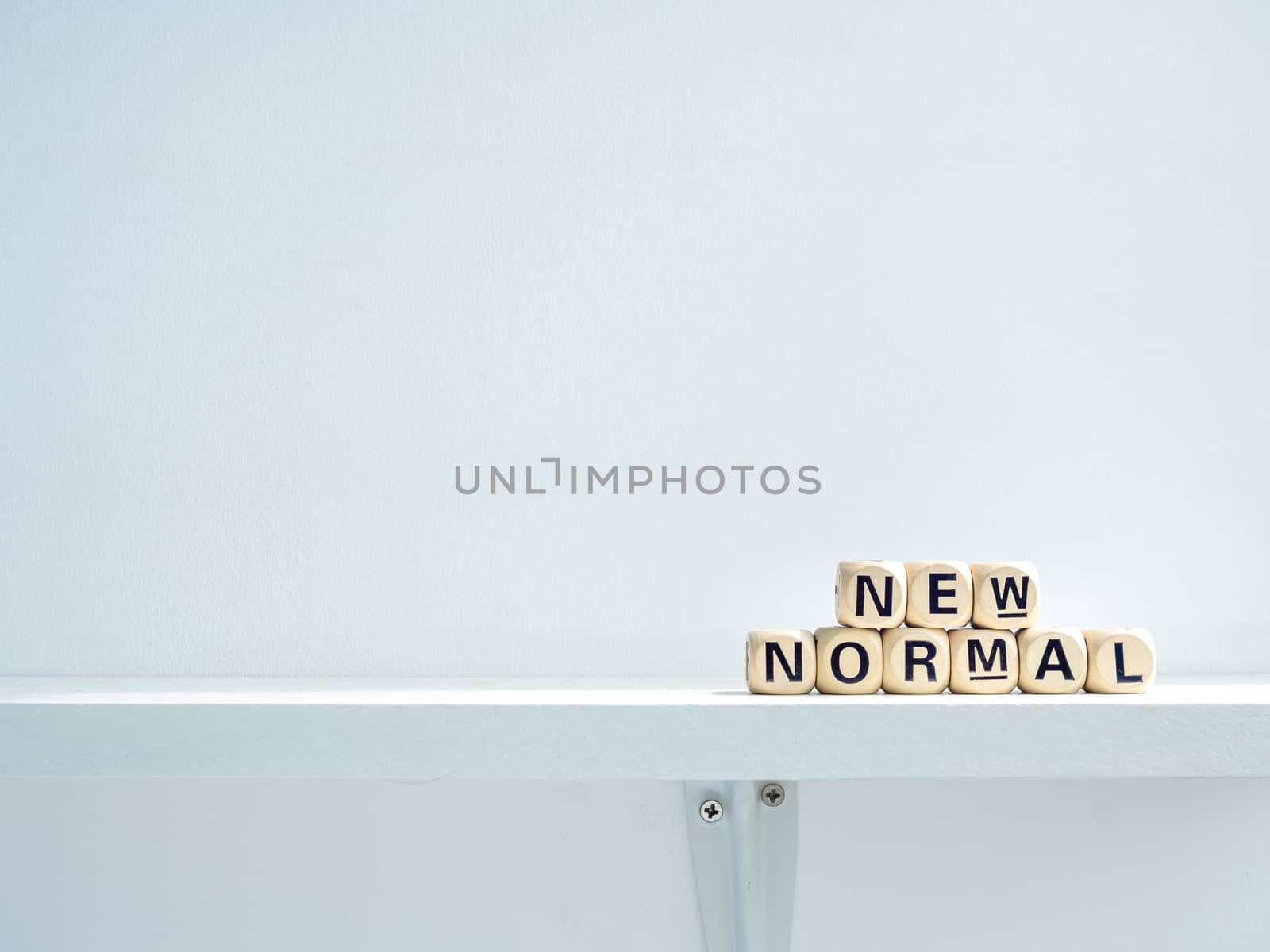 New Normal, words on wooden alphabet cube on shelf on white background with copy space. New normal after covid-19 pandemic concept.