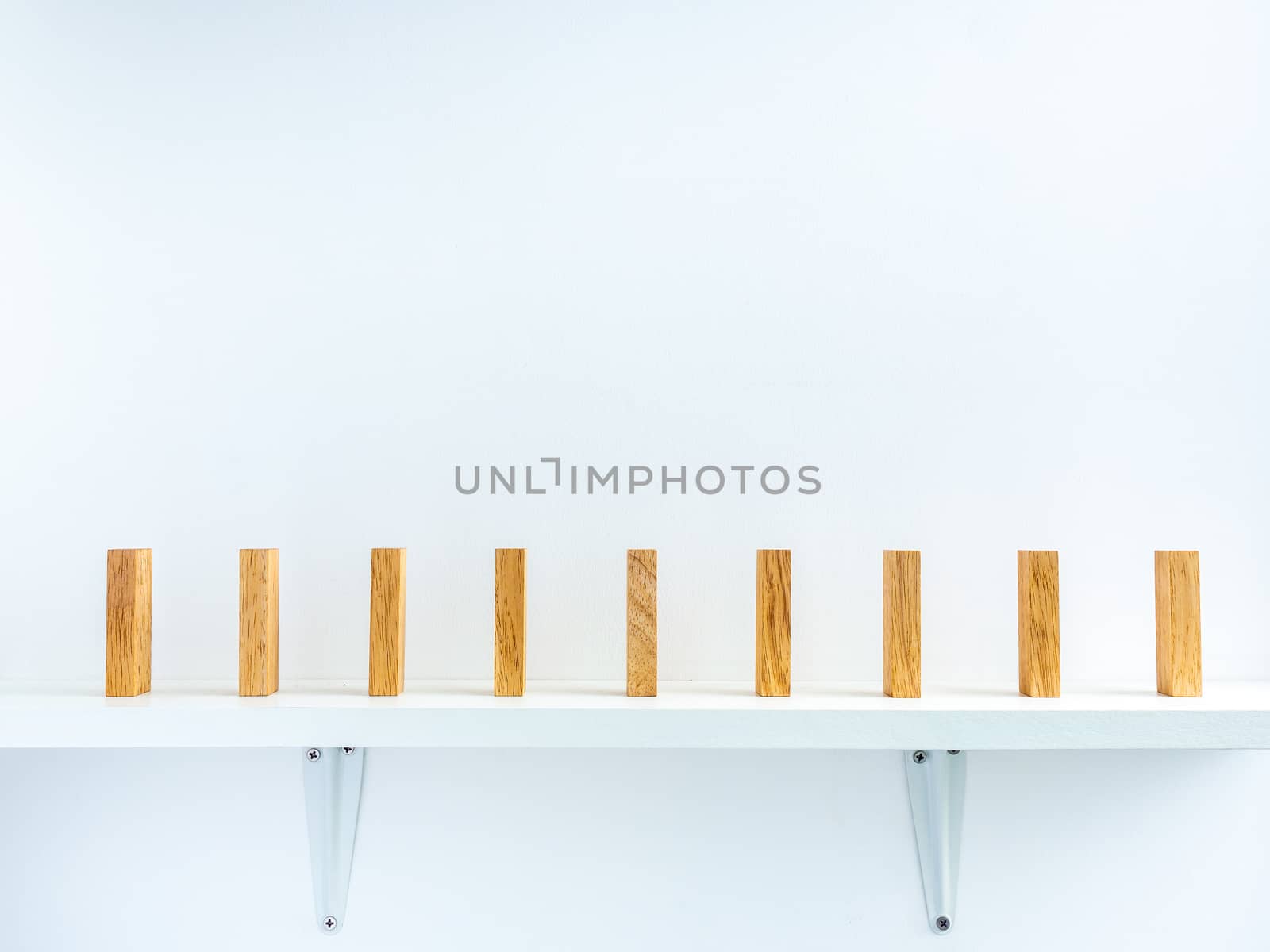 Social Distancing concept. Row of wooden dominoes with distance space on shelf on white background.