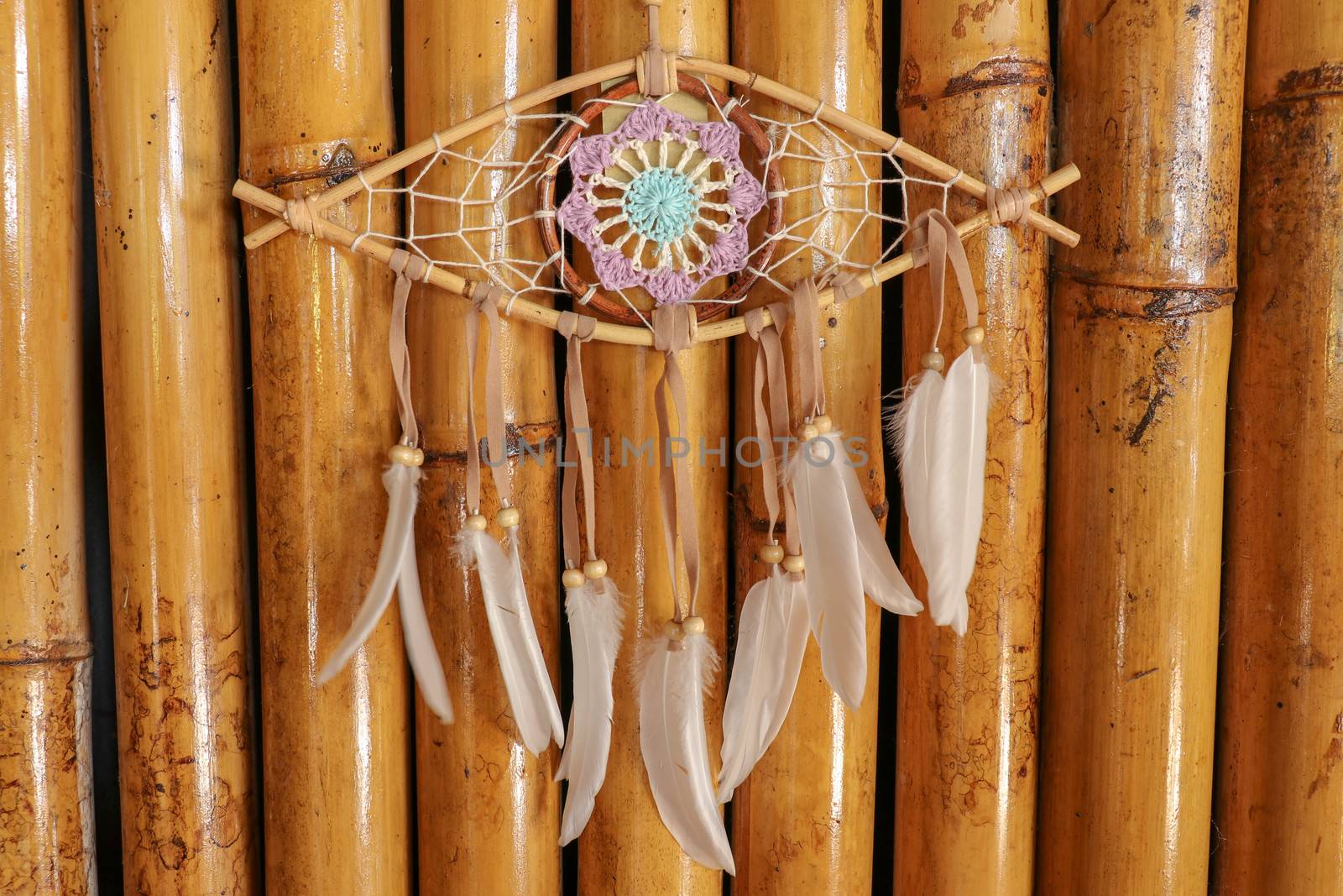 god eye of providence dreamcatcher with white feathers on a wodden background.