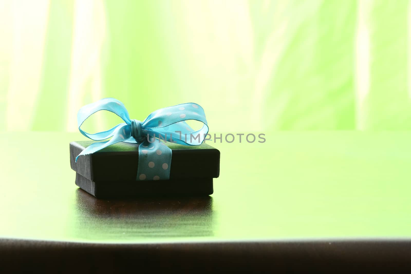 Presents on a table with a bow. Background space for copy. For Christmas, birthday or other holiday cards