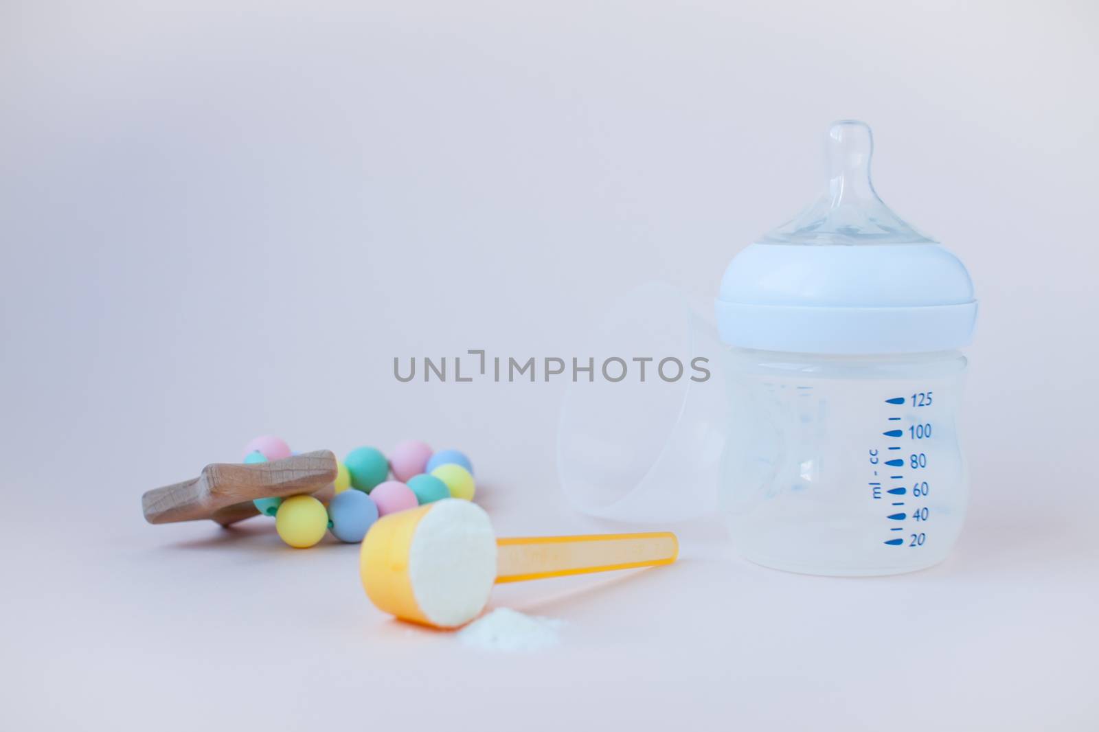 Artificial feeding of babies. Bottle for the mixture, measuring spoon, dry milk adapted mixture. Copy space for text. by malyshkamju