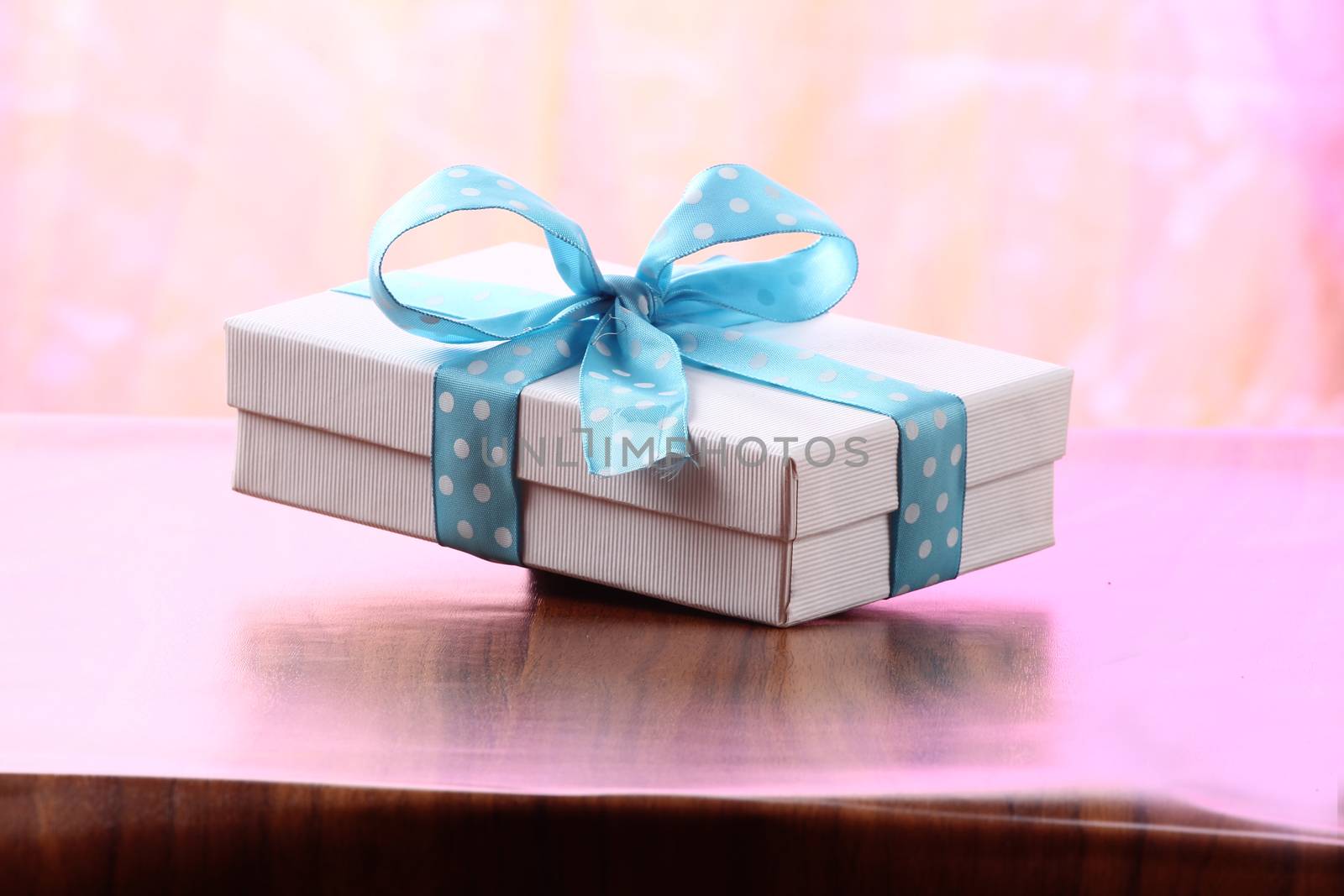 Presents on a table with a bow. Background space for copy. For Christmas, birthday or other holiday cards