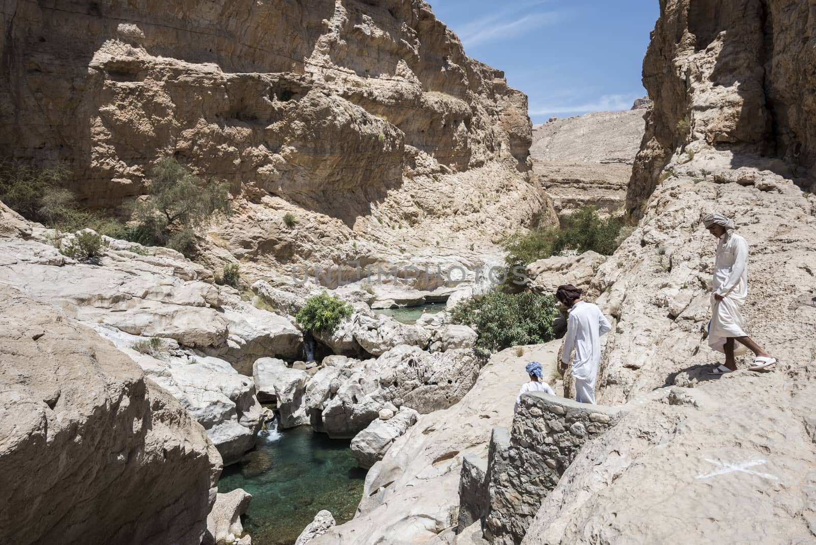 People walking and swimming in Wadi Bani Khalid, Oman, Middle Ea by GABIS