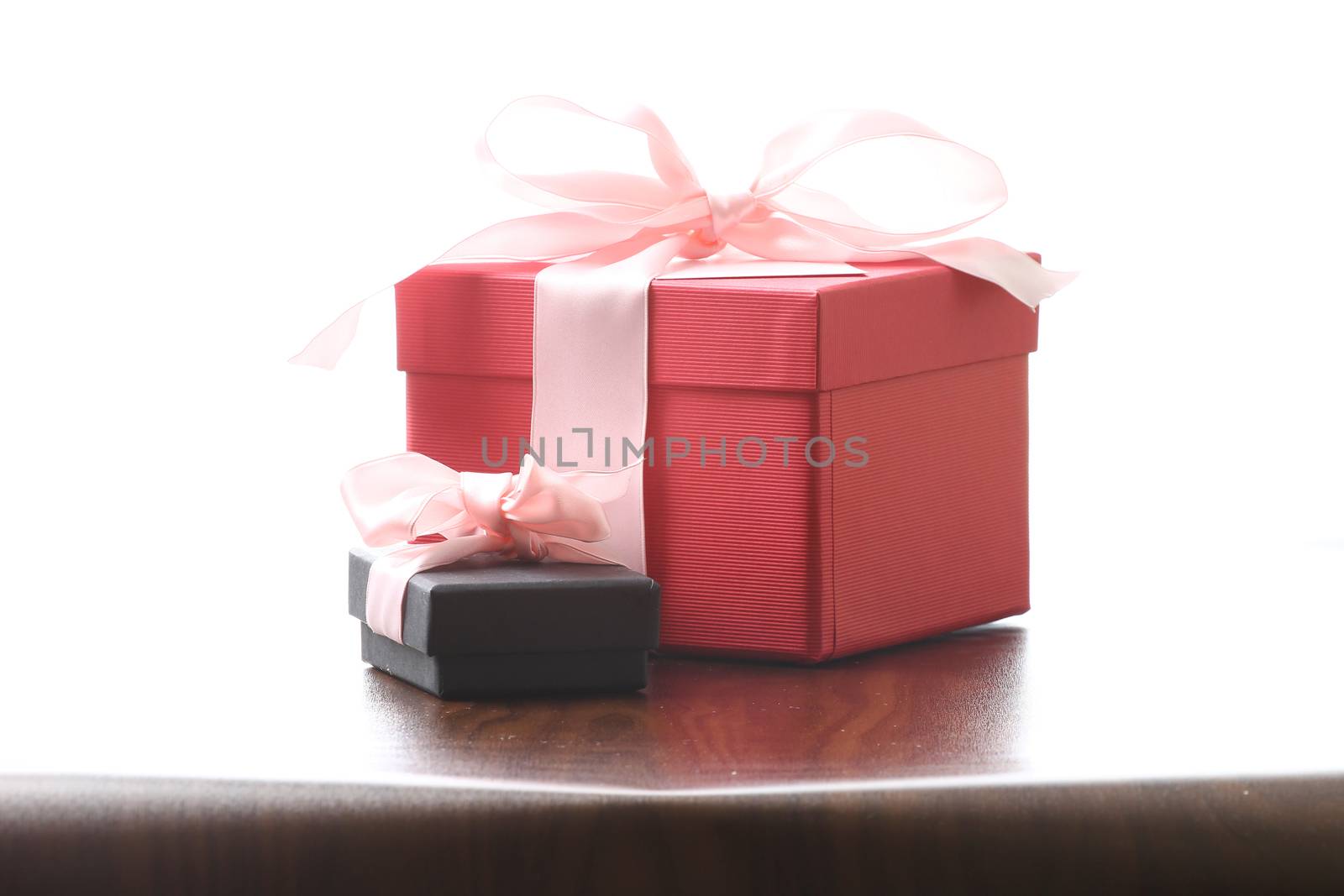 Presents on a table with a bow. Background space for copy. For Christmas, birthday or other holiday cards