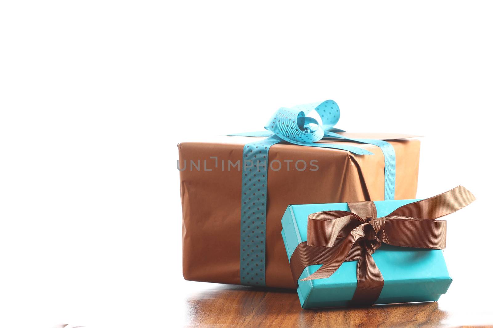 Presents on a table with a bow. Background space for copy. For Christmas, birthday or other holiday cards