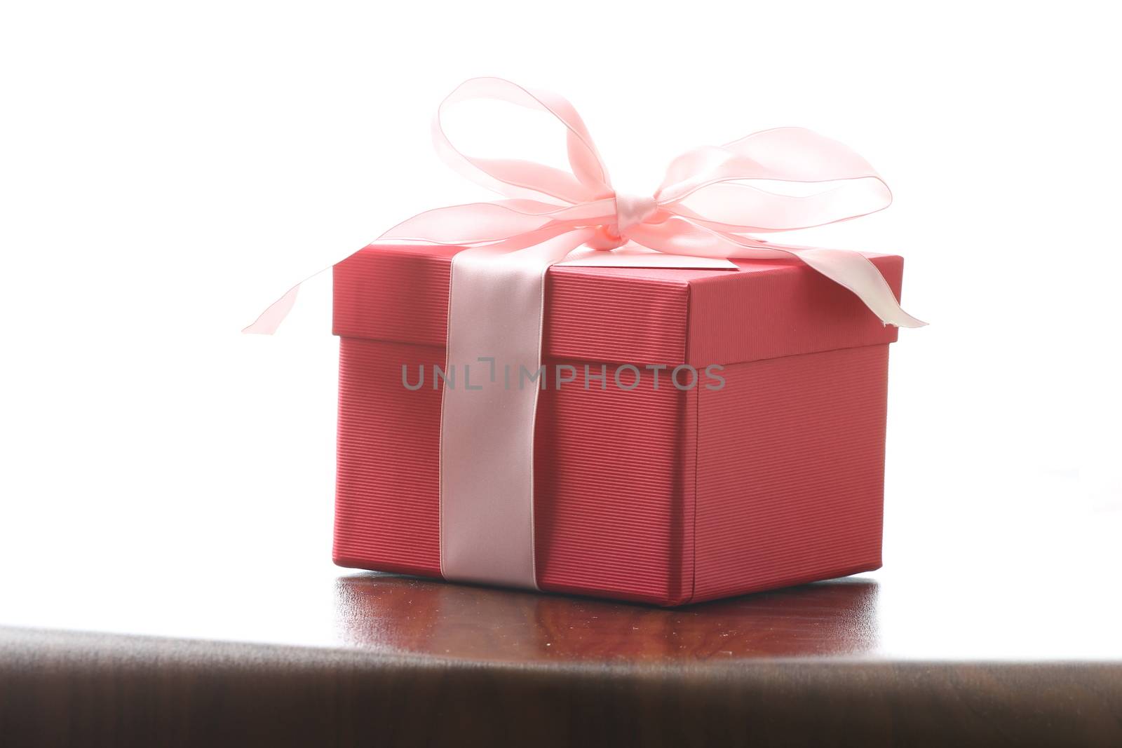 Presents on a table with a bow. Background space for copy. For Christmas, birthday or other holiday cards