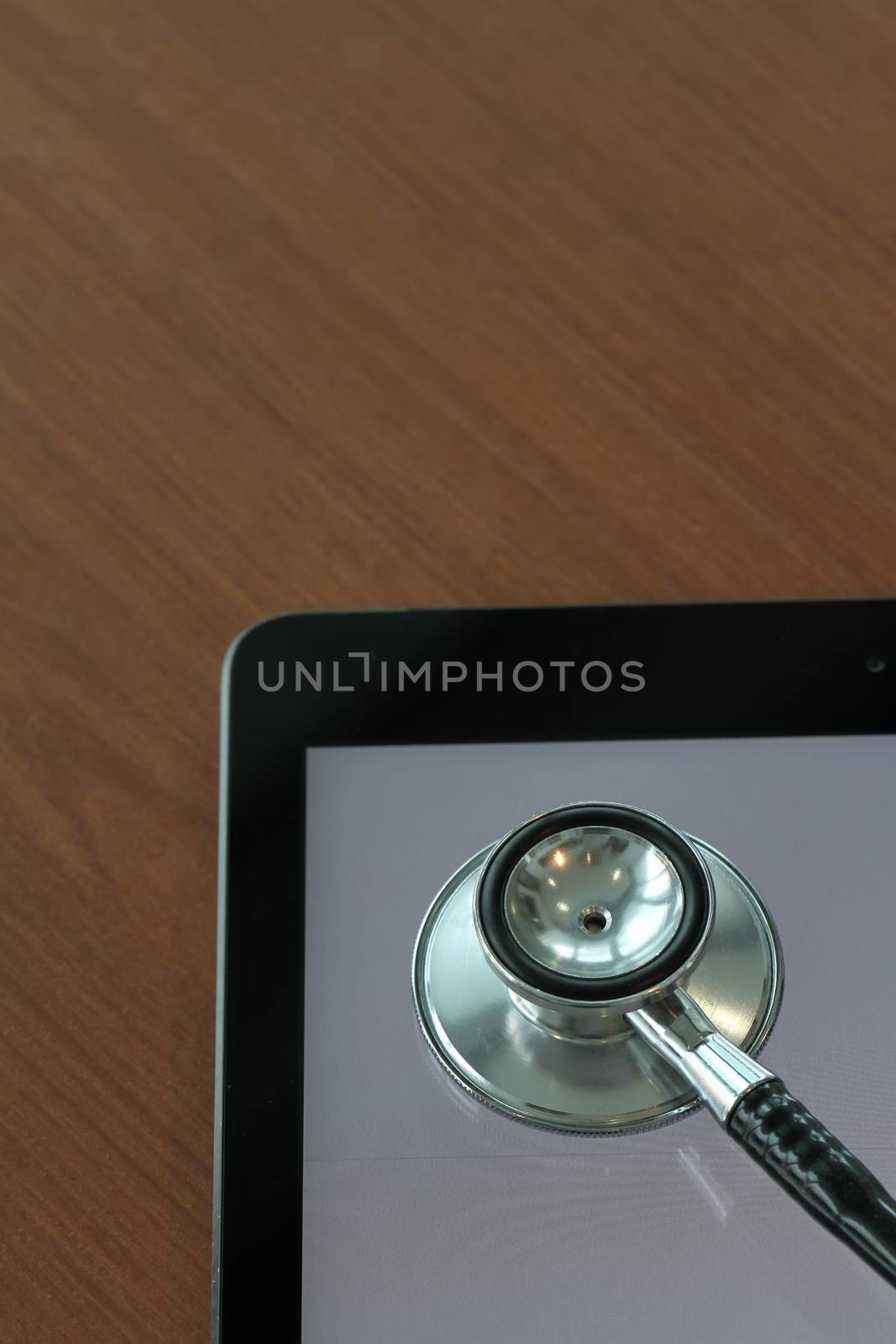 studio macro of a stethoscope and digital tablet on wood table b by everythingpossible