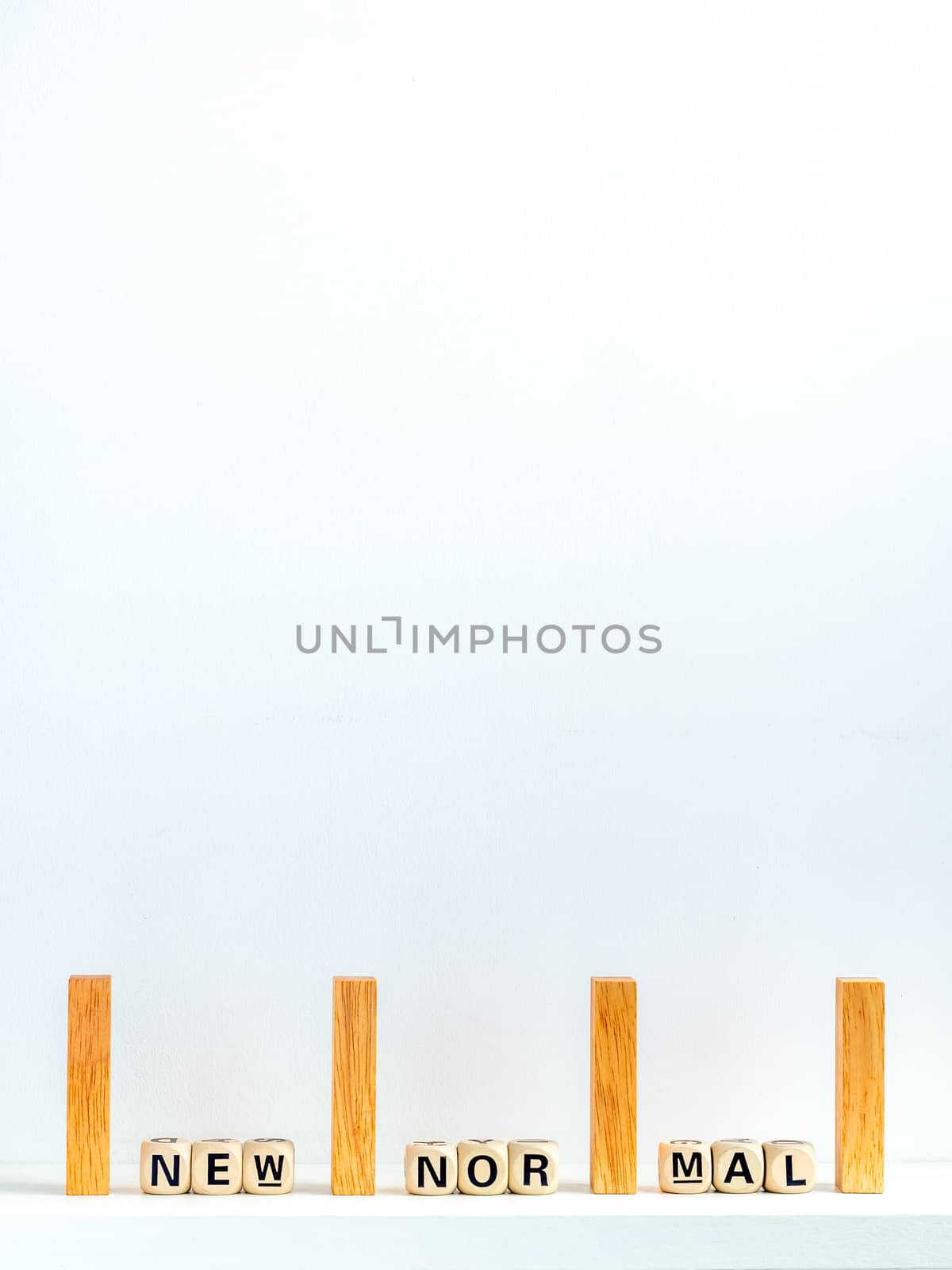 Social Distancing concept. Row of wooden dominoes with distance space and New Normal, words on wooden alphabet cube on white background with copy space, vertical style.