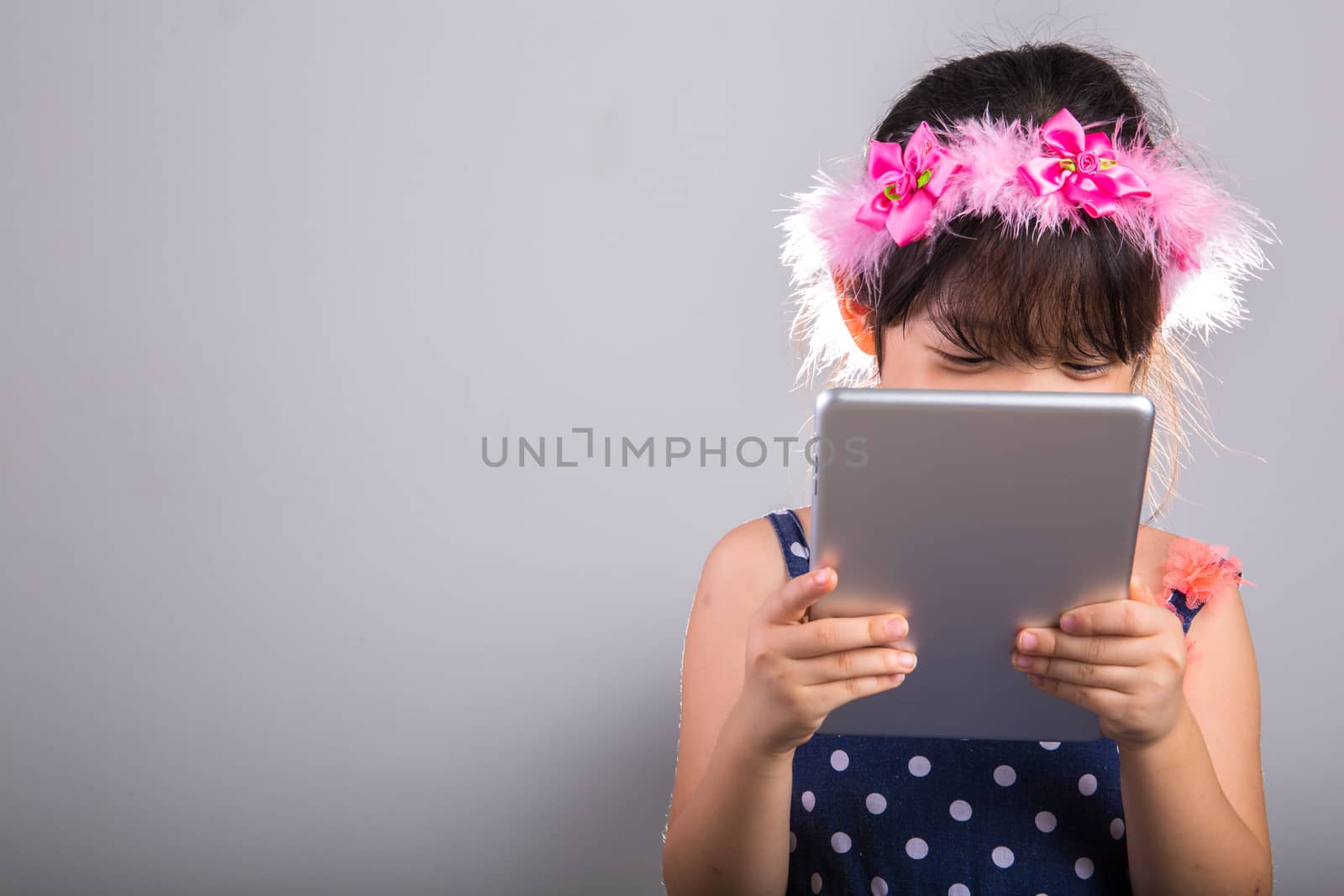 Background of Asian child is using tablet.