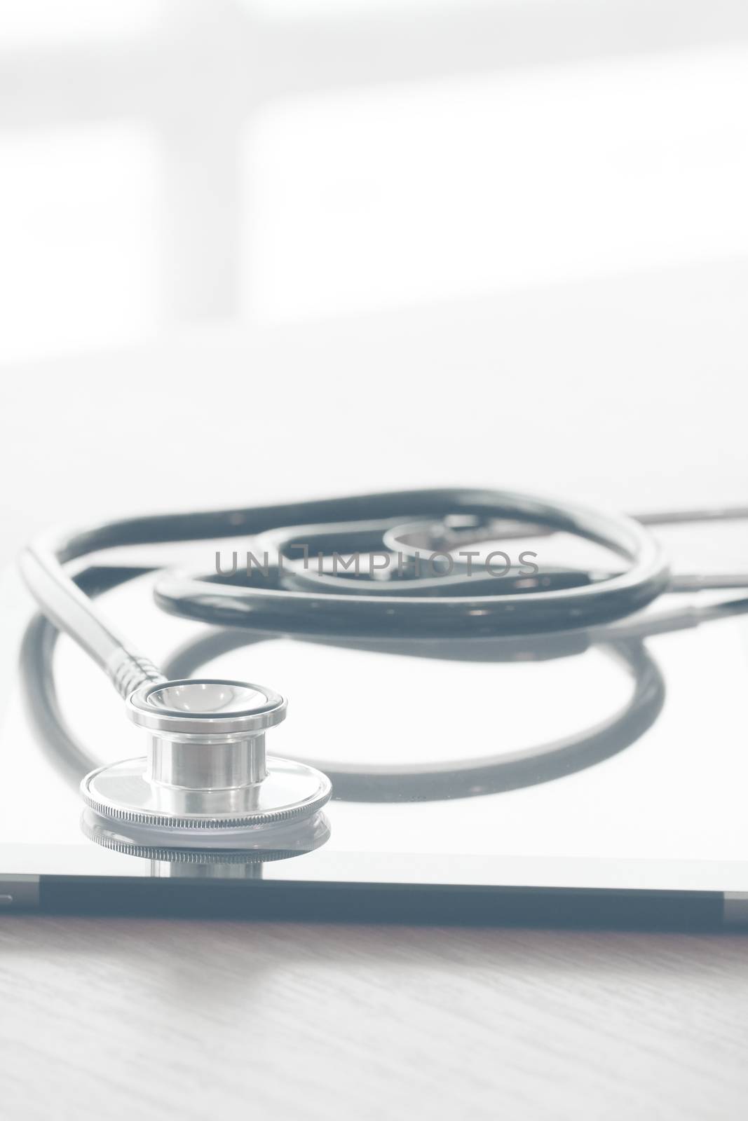 studio macro of a stethoscope and digital tablet on wood table background copy space