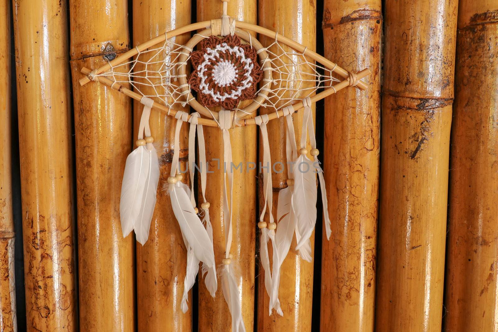 god eye of providence dreamcatcher with white feathers on a wodden background.