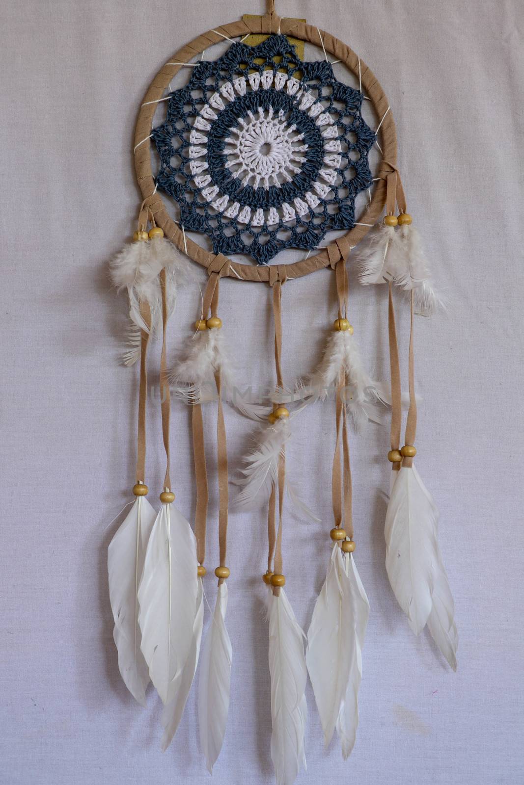 Blue Dreamcatcher with feathers and beads isolated on a white background.