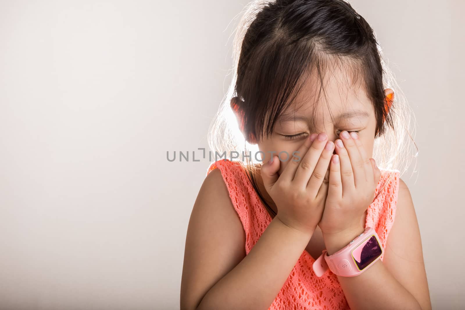 Little girl is sneezing because she is sick.