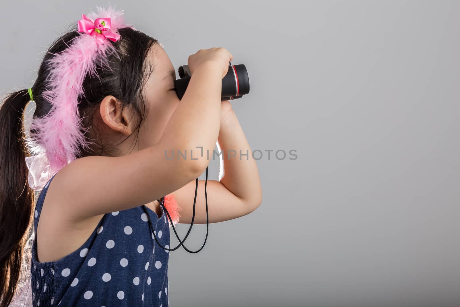 Background of Asian child is exploring through binoculars.