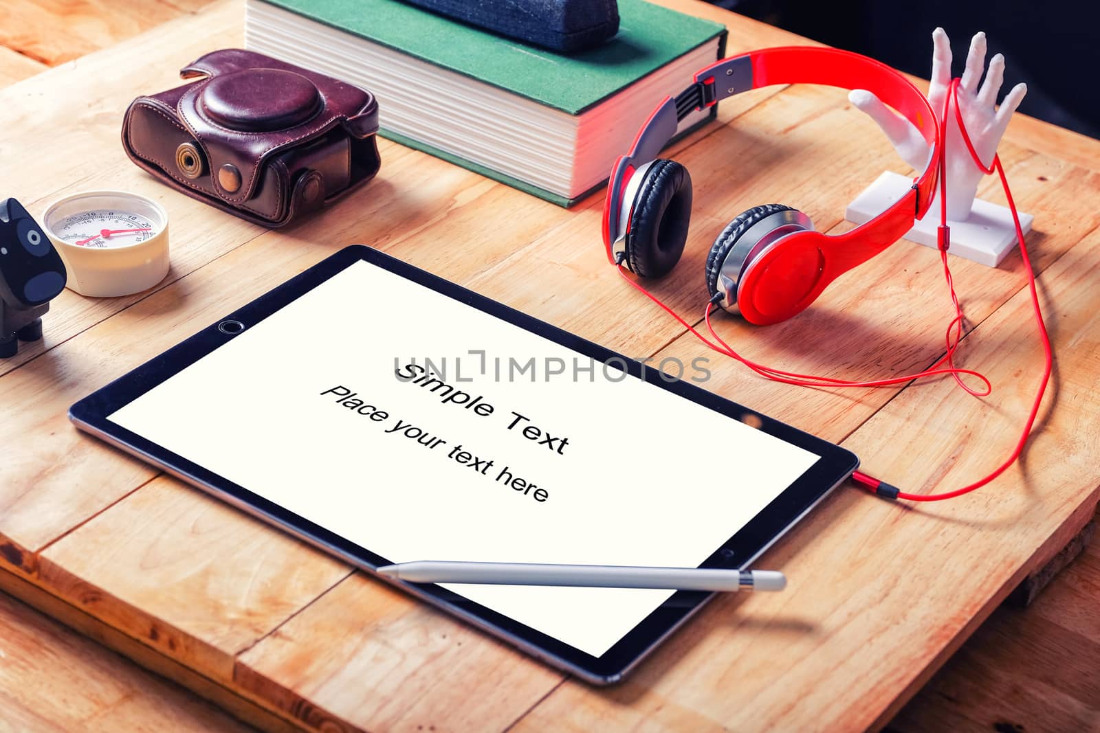 Office workplace with tablet and headphone on wood table.