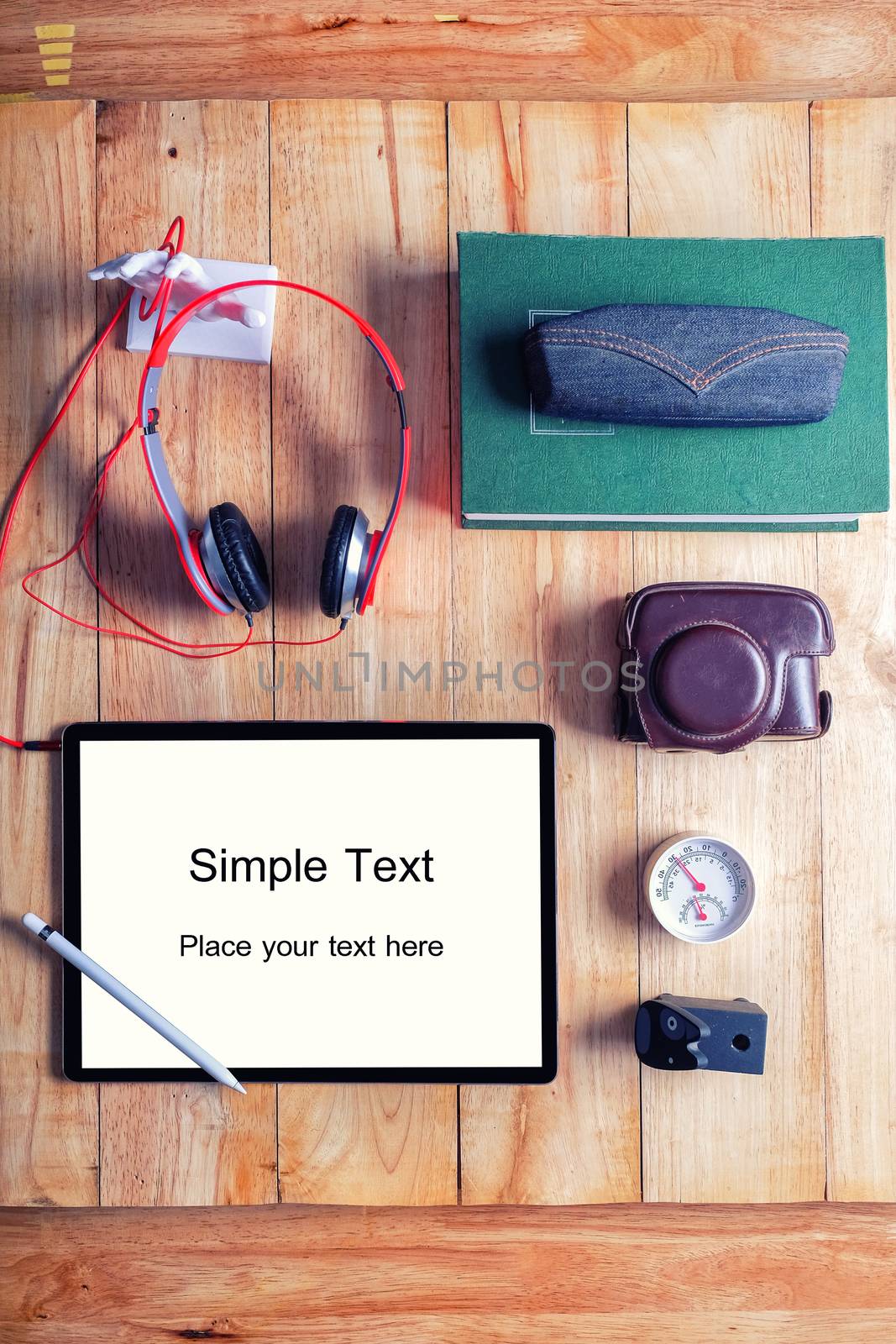 Office workplace with tablet and headphone on wood table.