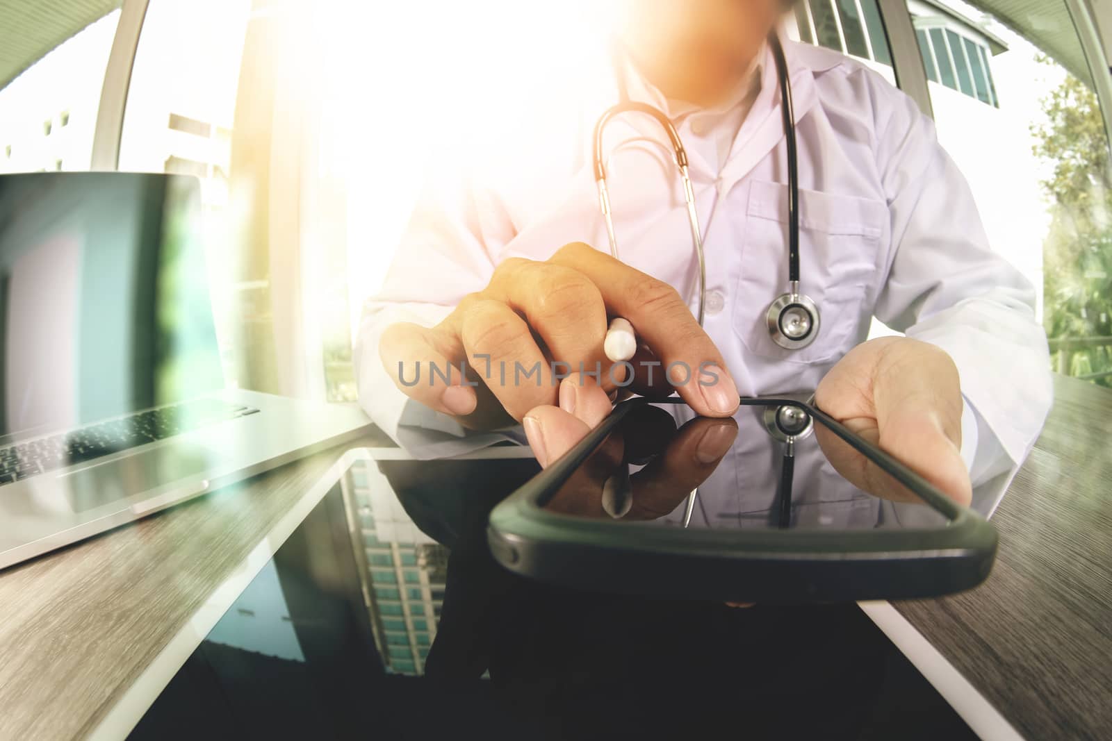 Medicine doctor hand working with modern smart phone and digital tablet computer with stethoscope as medical network concept