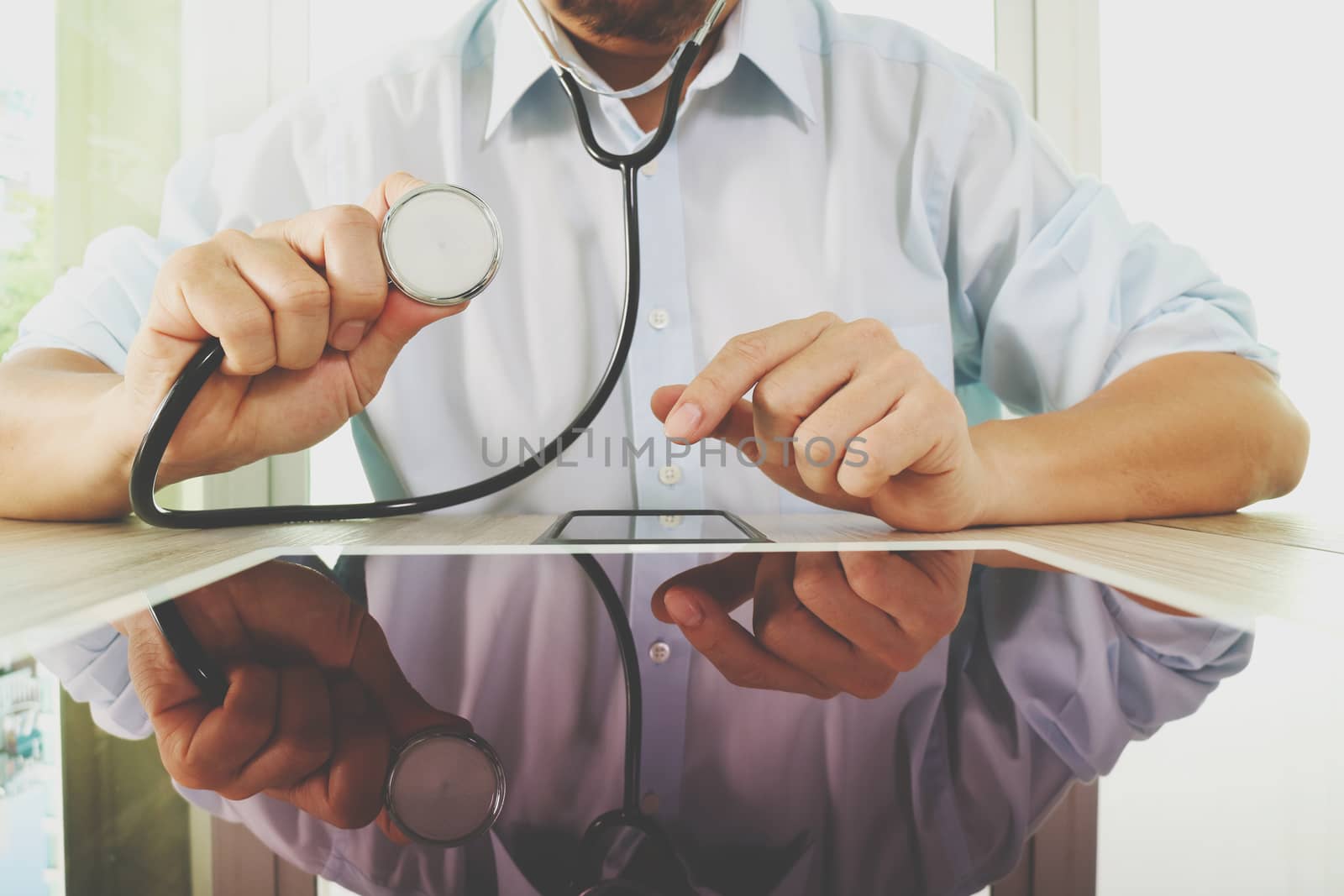 Medicine doctor hand holding stethoscope with modern tablet computer as medical network concept