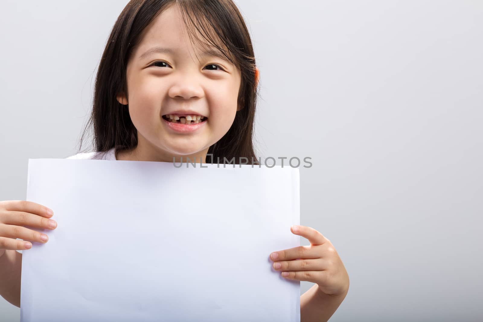Studio isolated kid holding white sheet of blank paper.