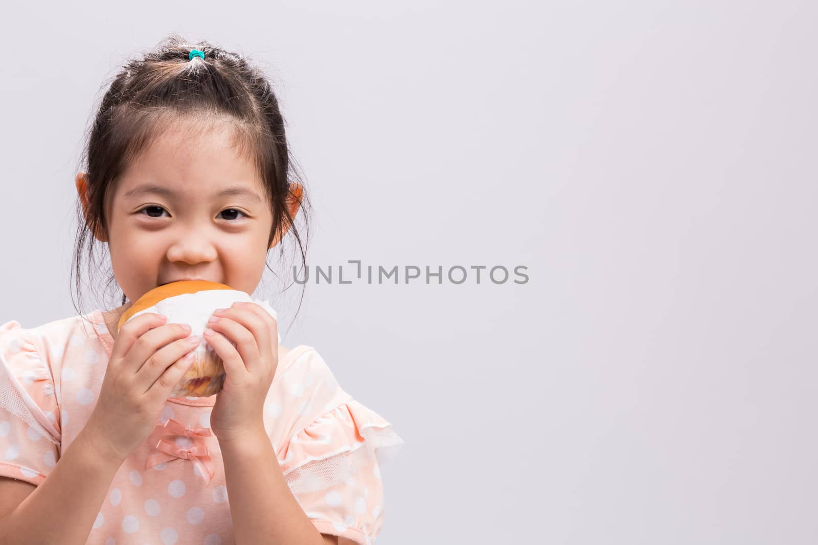 Little girl is eating hamburger with happiness.