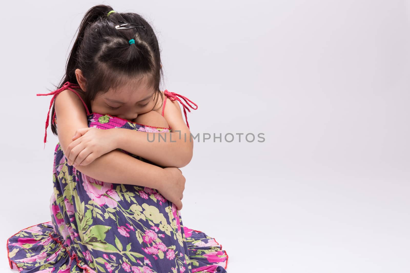 Worry little girl on isolated white background.