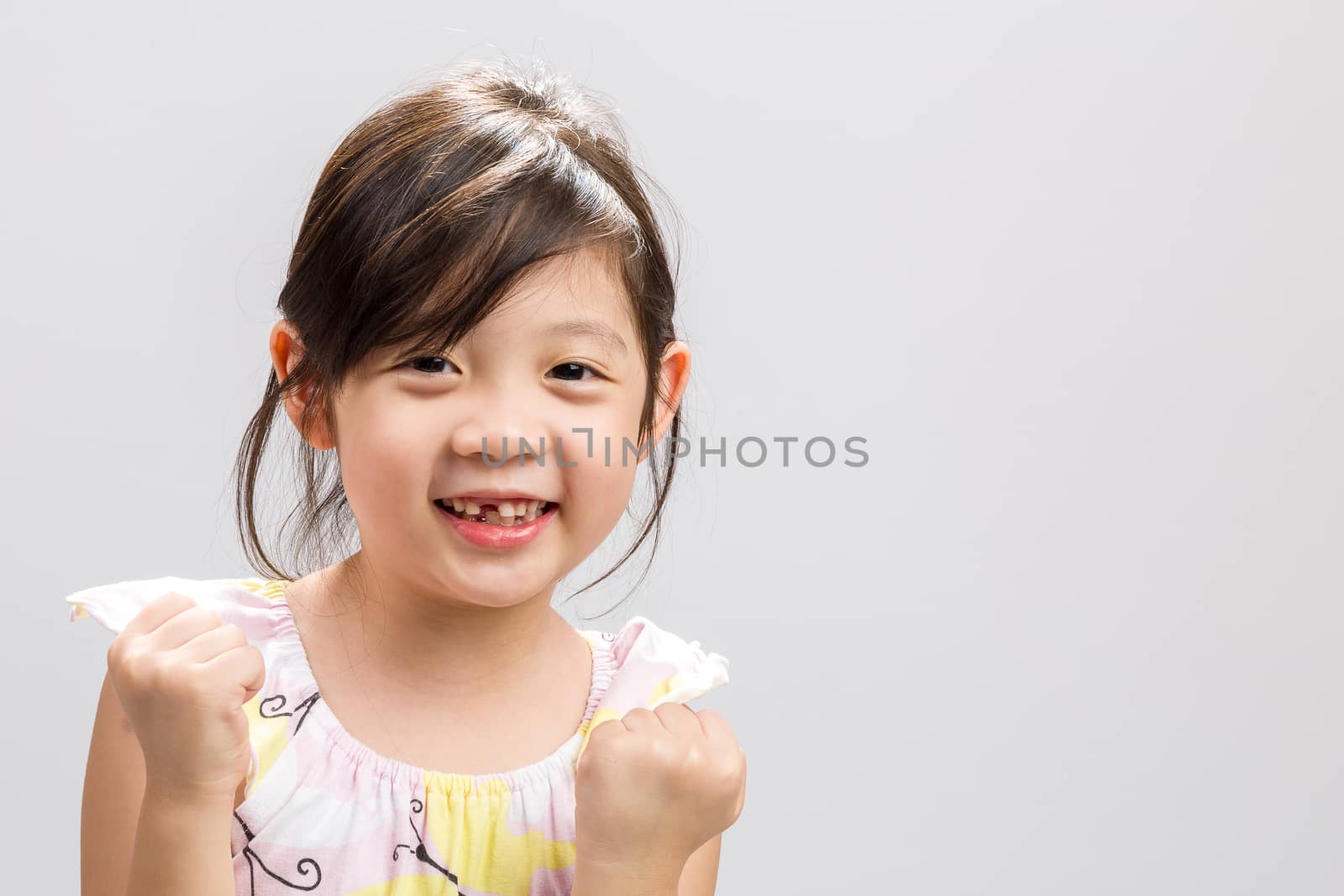 Cute Asian girl expressing success concept, studio isolated white background.