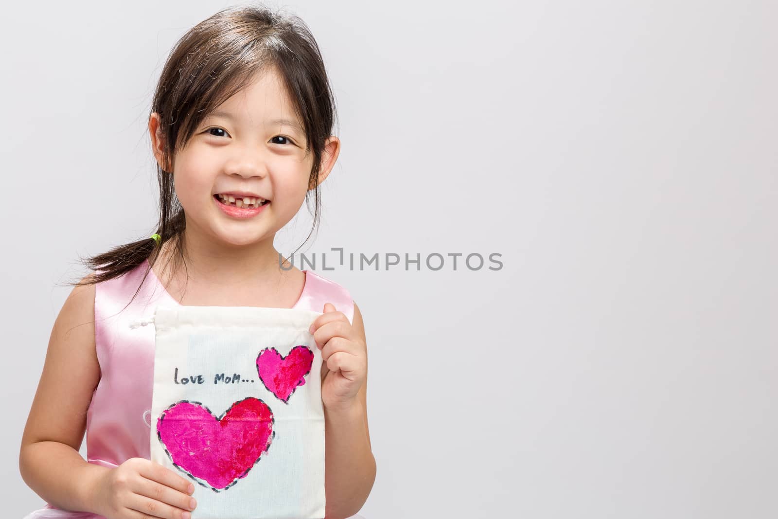 Cute Asian girl showing LOVE MOM message, studio isolated white background.