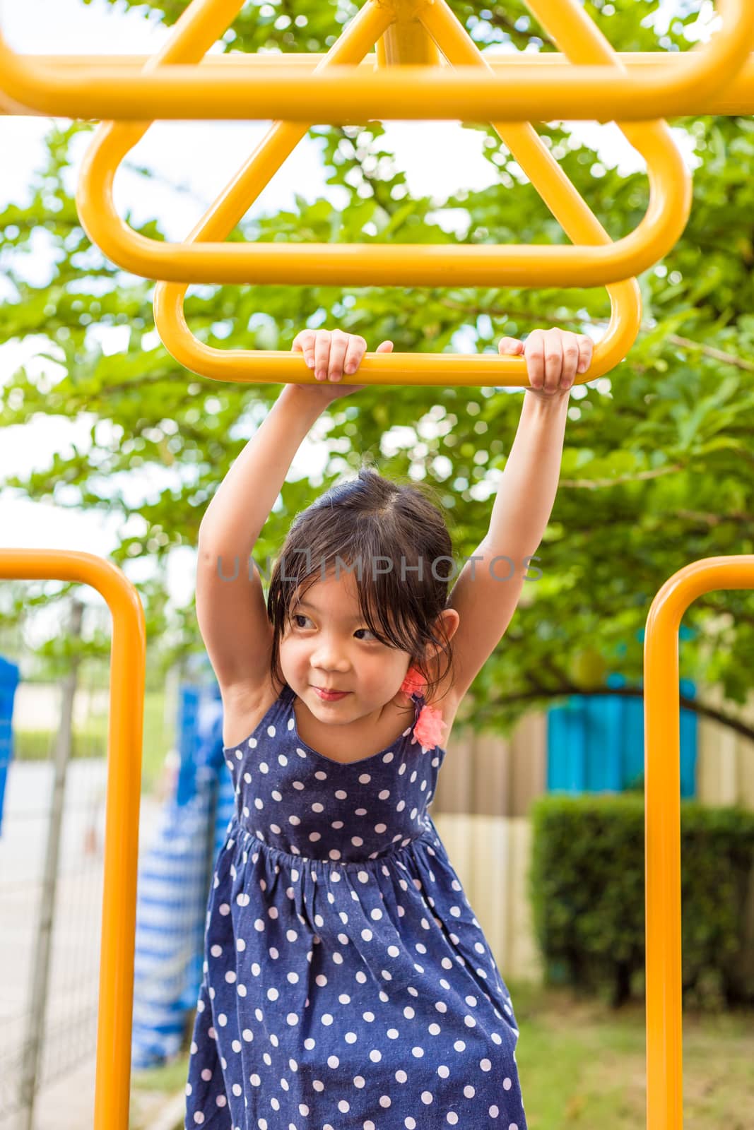 Young girl playing outdoor equipment with happiness.
