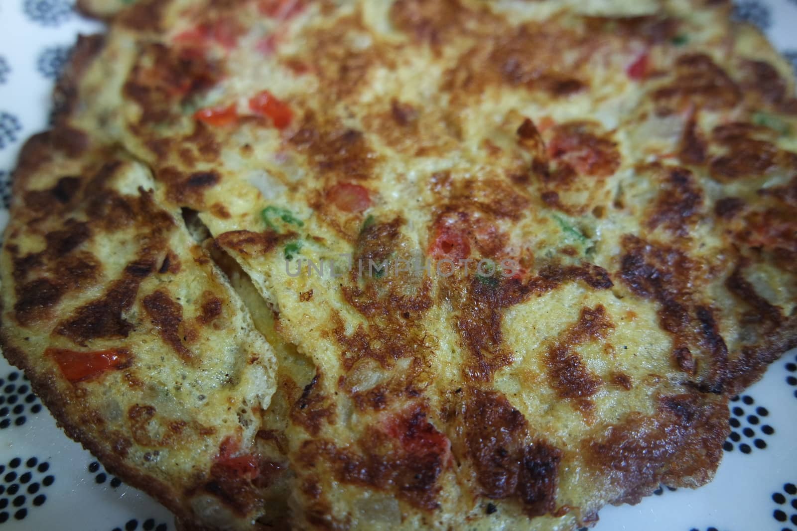 Close-up viewof egg omelet with peppers and spices sprinkled by Photochowk