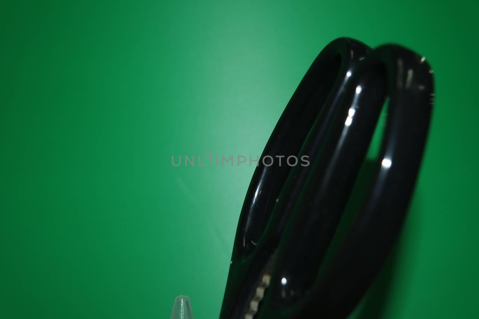 Closeup view of a stationery pot containing stationery items. stationery pot in front of a green background.