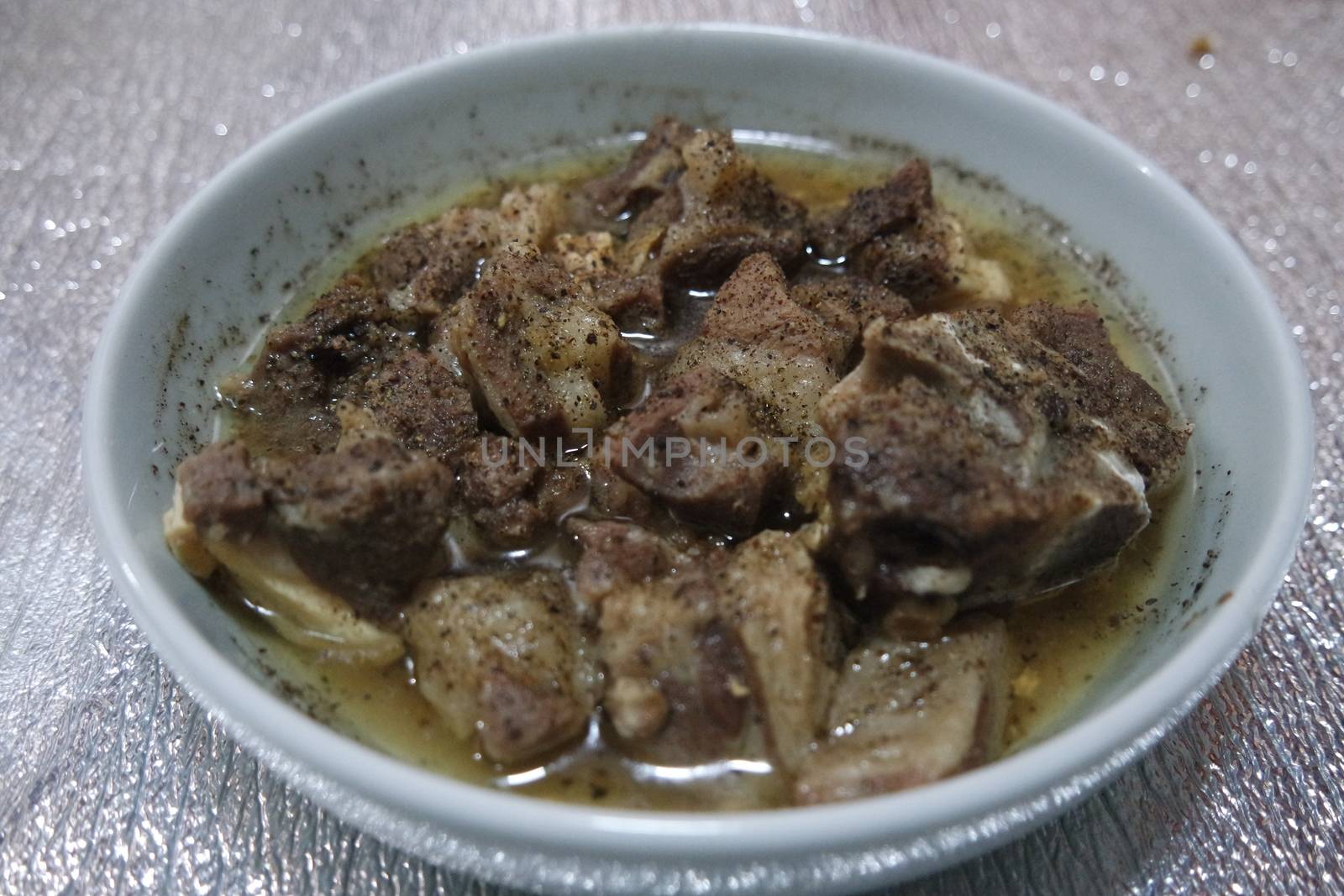 Top view of siri paaye or paya dish garnished with diced ginger, long coriander and black pepper. This dish is popular in Pakistan and Bangladesh