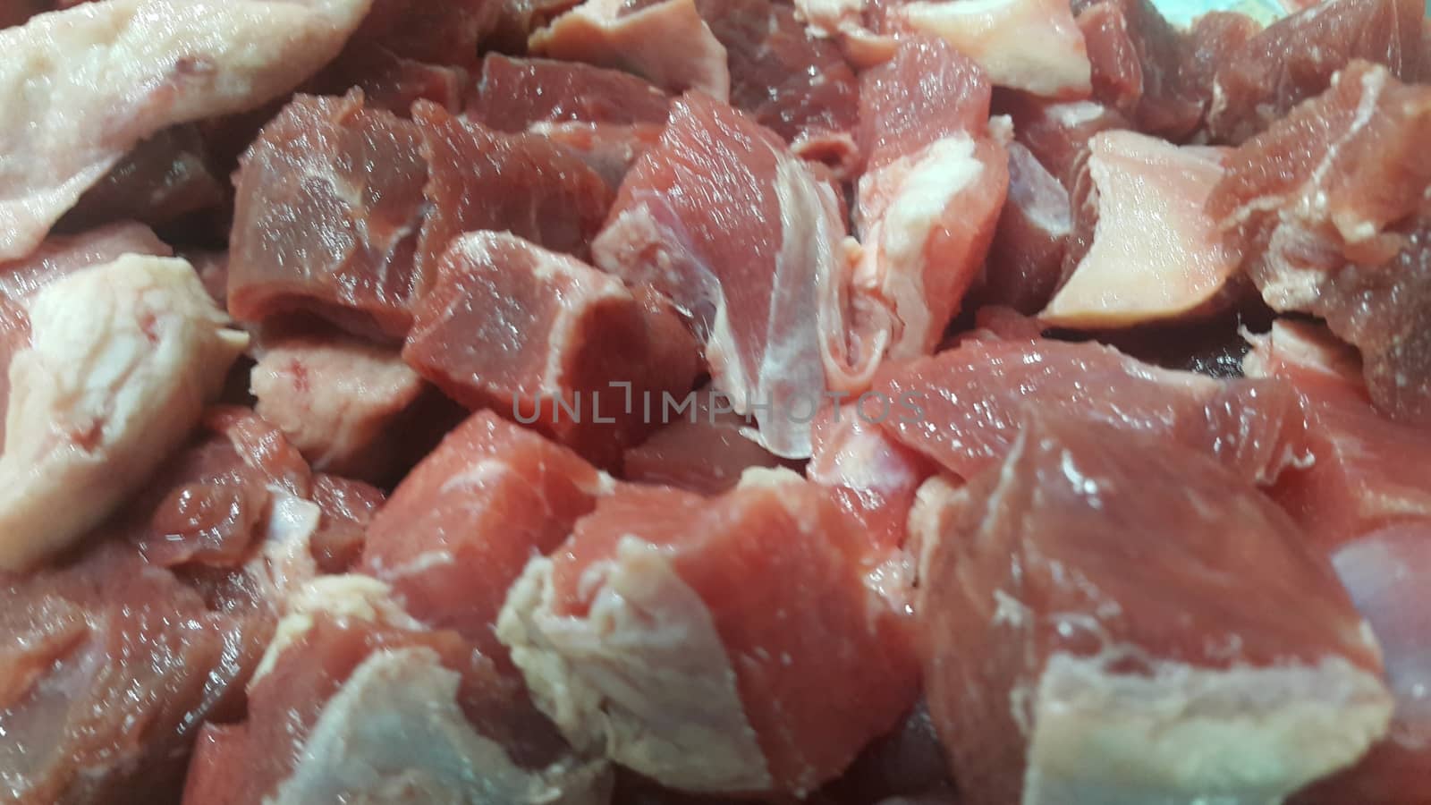 Close up view of fresh finely chopped meat cubes. Red meat small steaks with whitish meat fat.