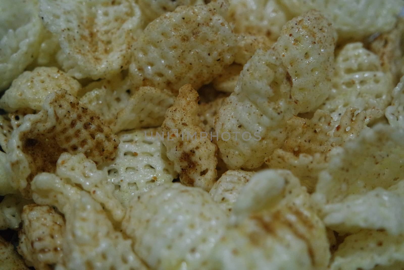 Closeup view of freshly fried chips as fast food for tea break. Potato chips with spices sprinkled on it. Fast food background for advertisements.