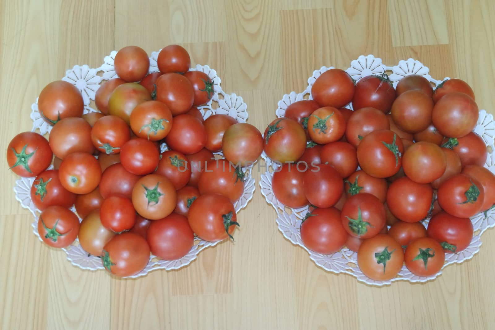 Close-up view of red tomatoes in white basket on a wooden floor in market for sale. A fruit background for text and advertisements