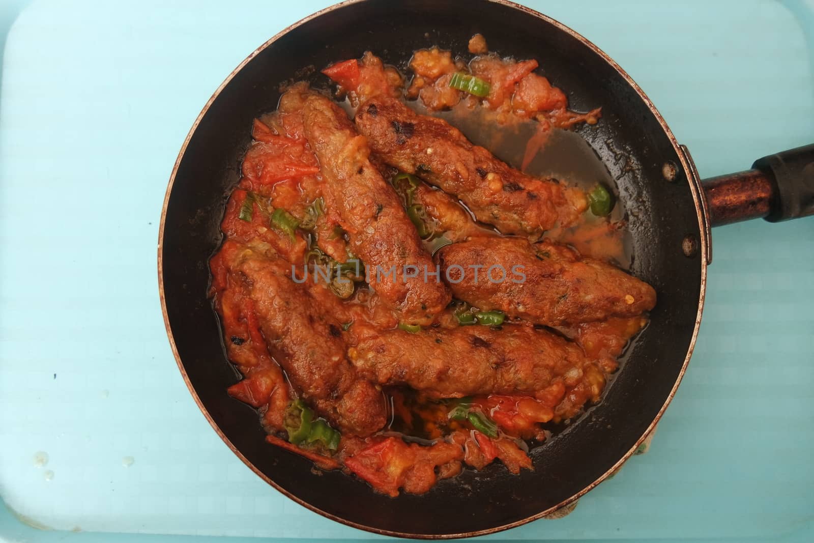 Closeup view of delicious spicy home made fried kebab with green mint leaves and green pepper sprinkled on it