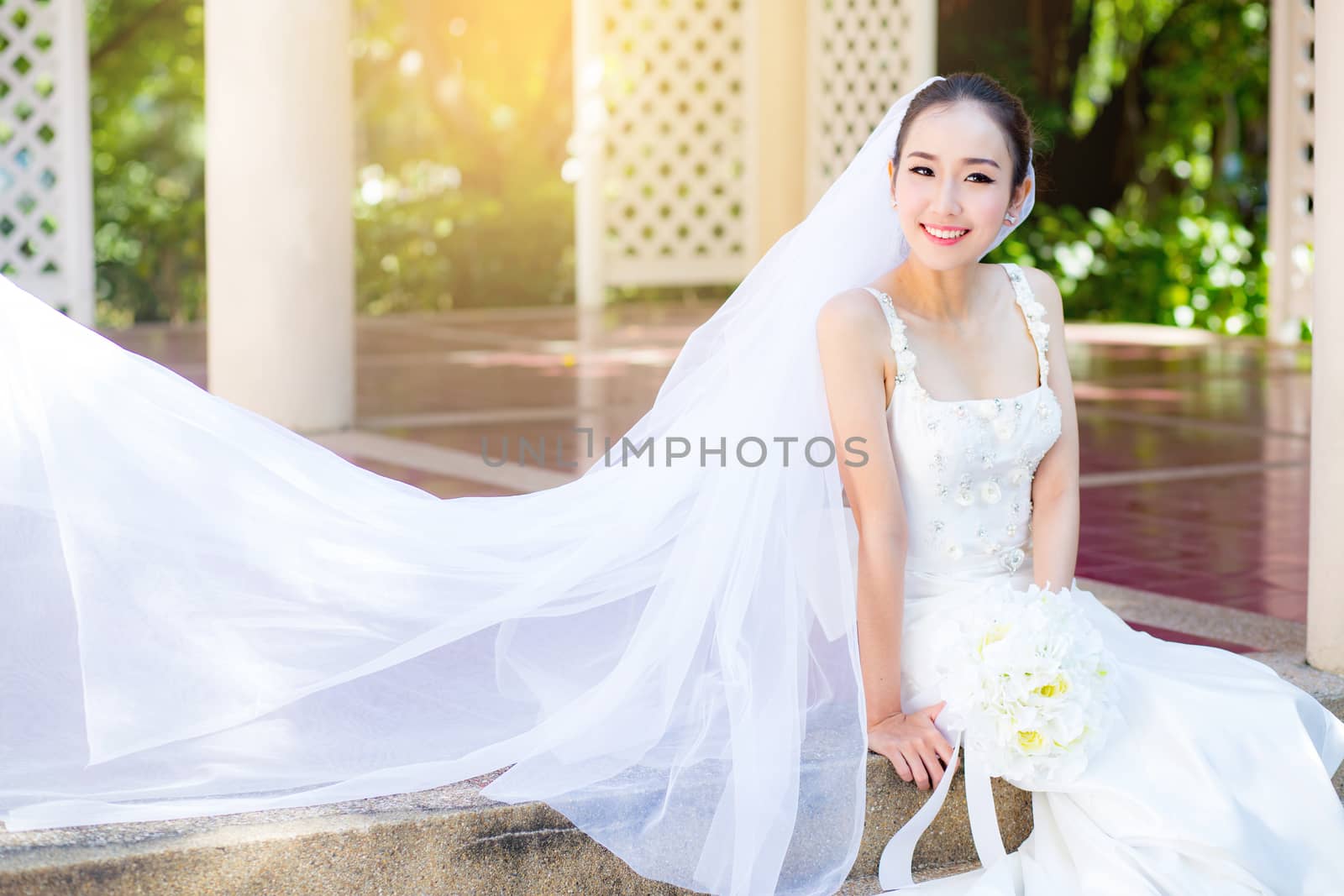 bride is sitting with flowers. Beautiful Young woman posing in p by nnudoo