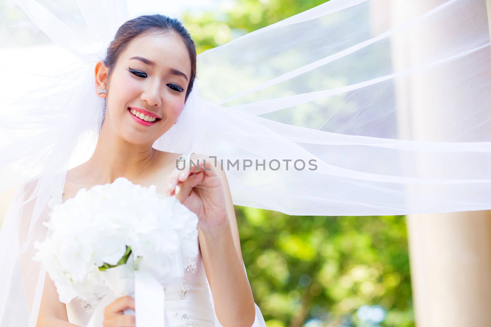 beautiful young woman on wedding day in white dress in the garden. Female portrait in the park.