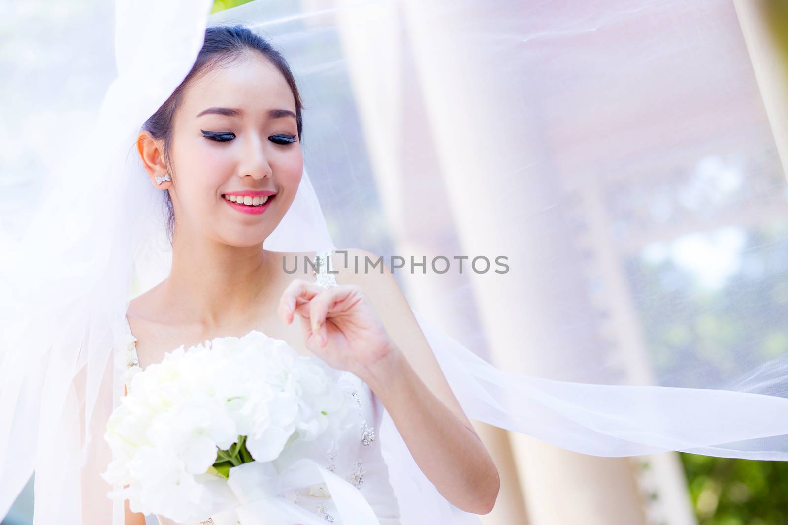 beautiful young woman on wedding day in white dress in the garden. Female portrait in the park.