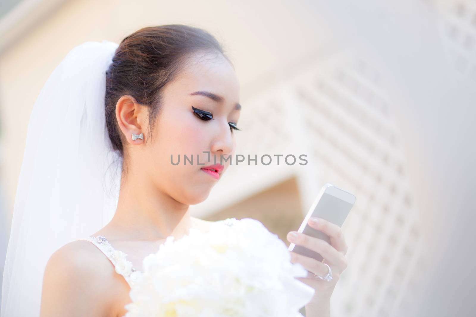 bride talking on cell phone in wedding dress by nnudoo