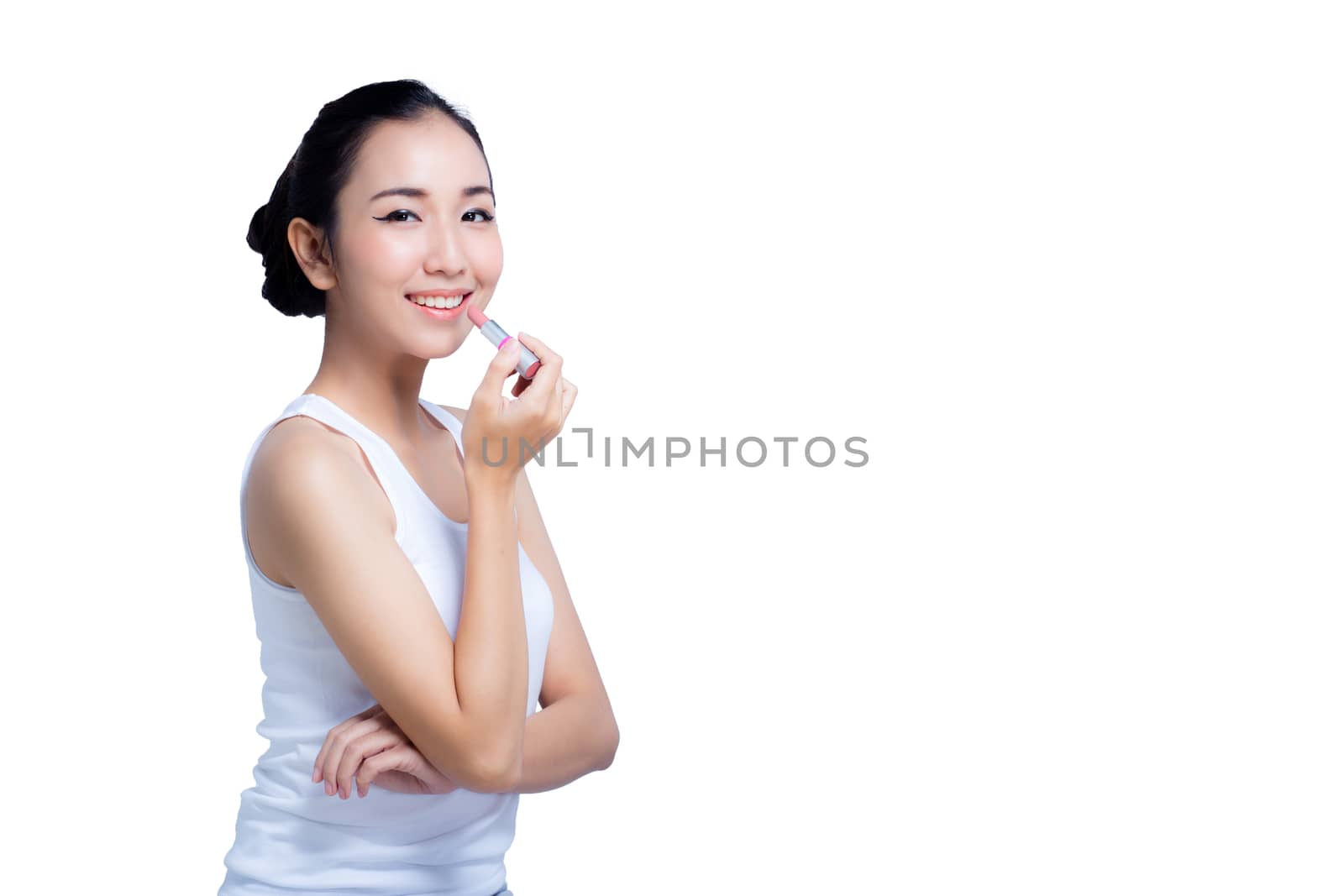 attractive young woman applying pink glossy lipstick isolated on white background