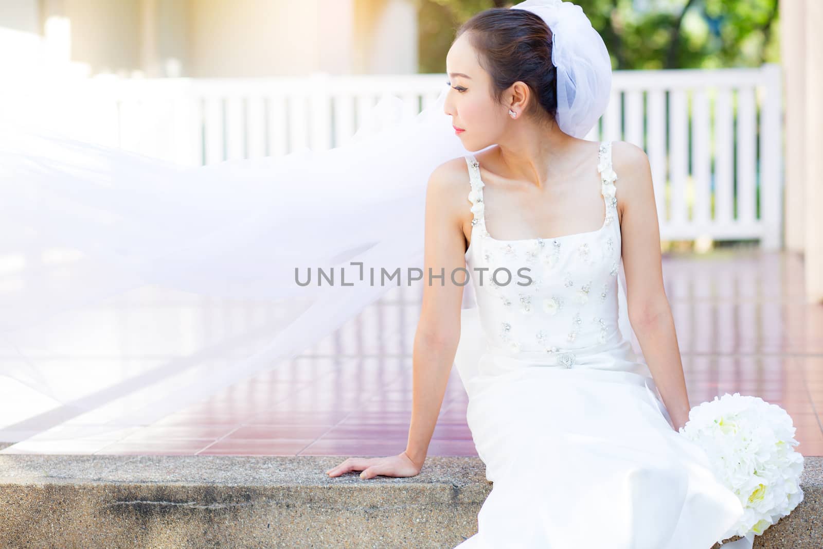 bride is sitting with flowers. Beautiful Young woman posing in p by nnudoo