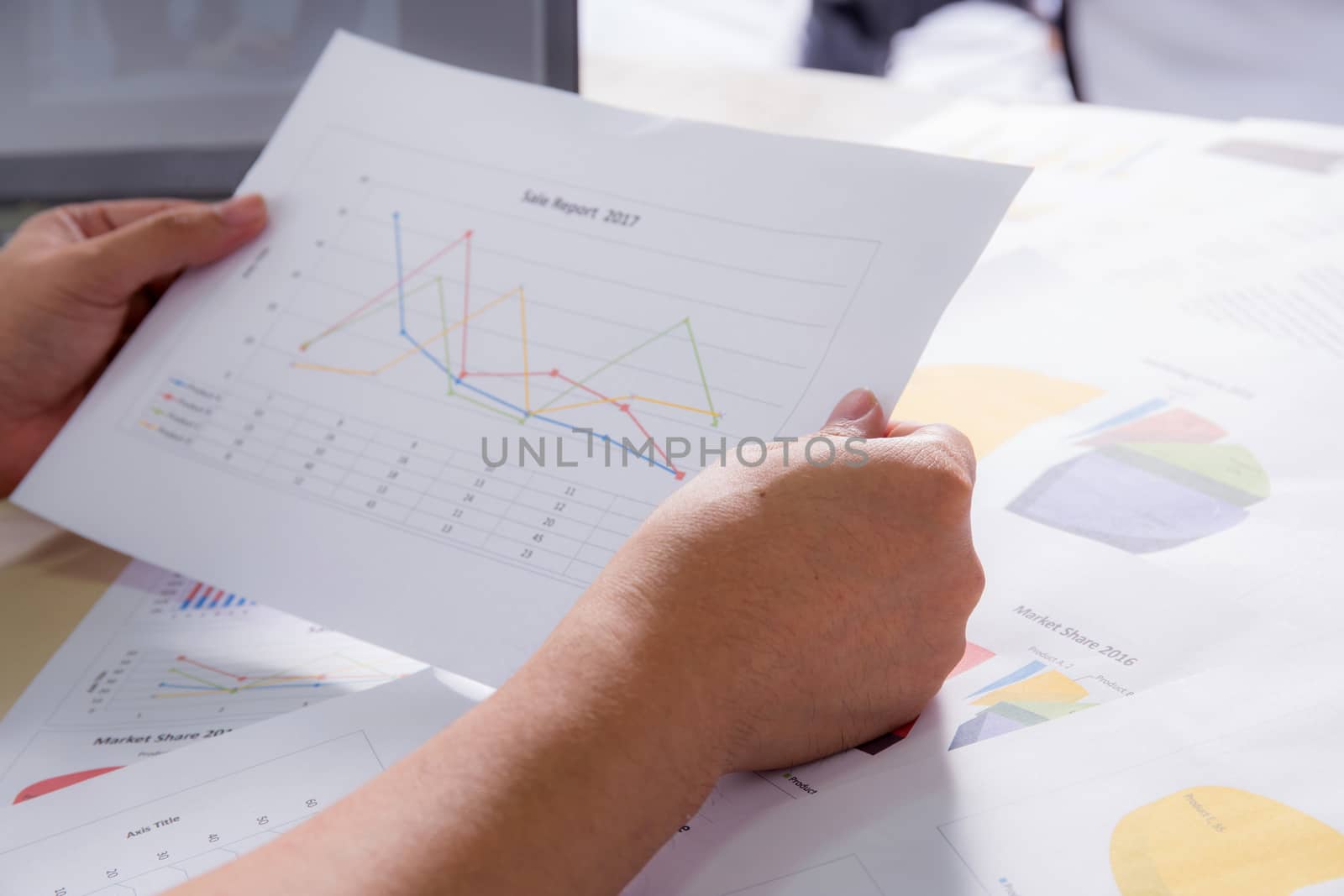 Financial paper charts with hold hand, graphs and notebook on the table