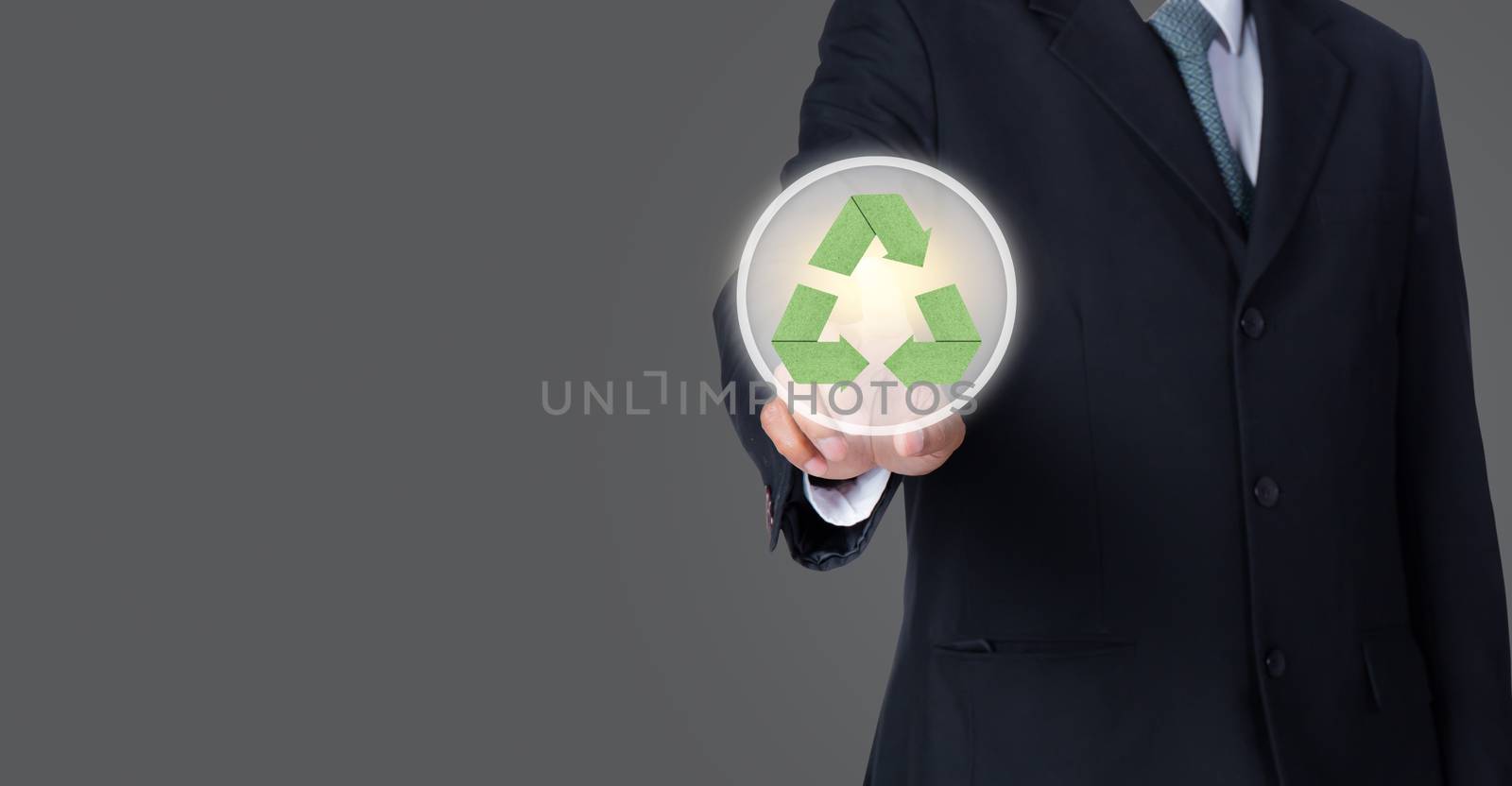 business man pointing at green recycle symbol with gray backgrou by nnudoo