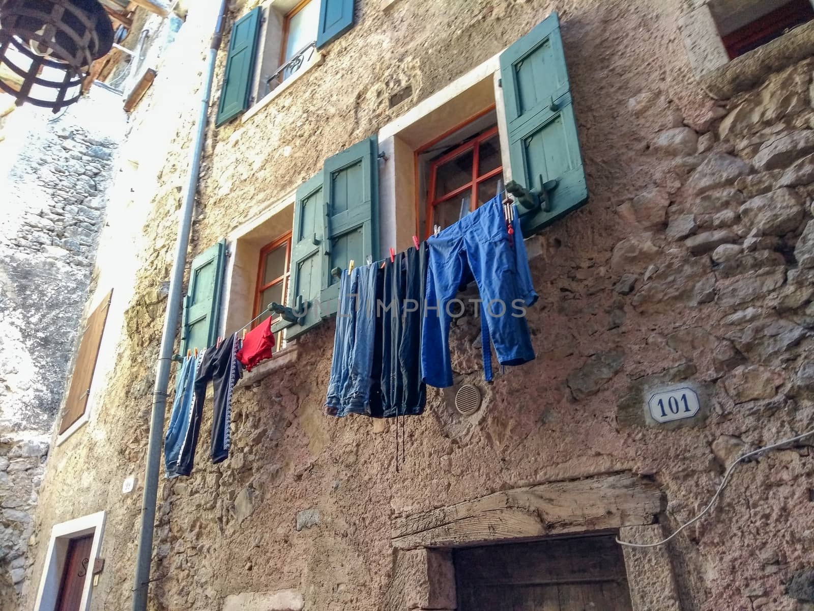 Old traditions in Europe: clothes hung out to dry under a window of a stone house in an ancient Italian village by robbyfontanesi