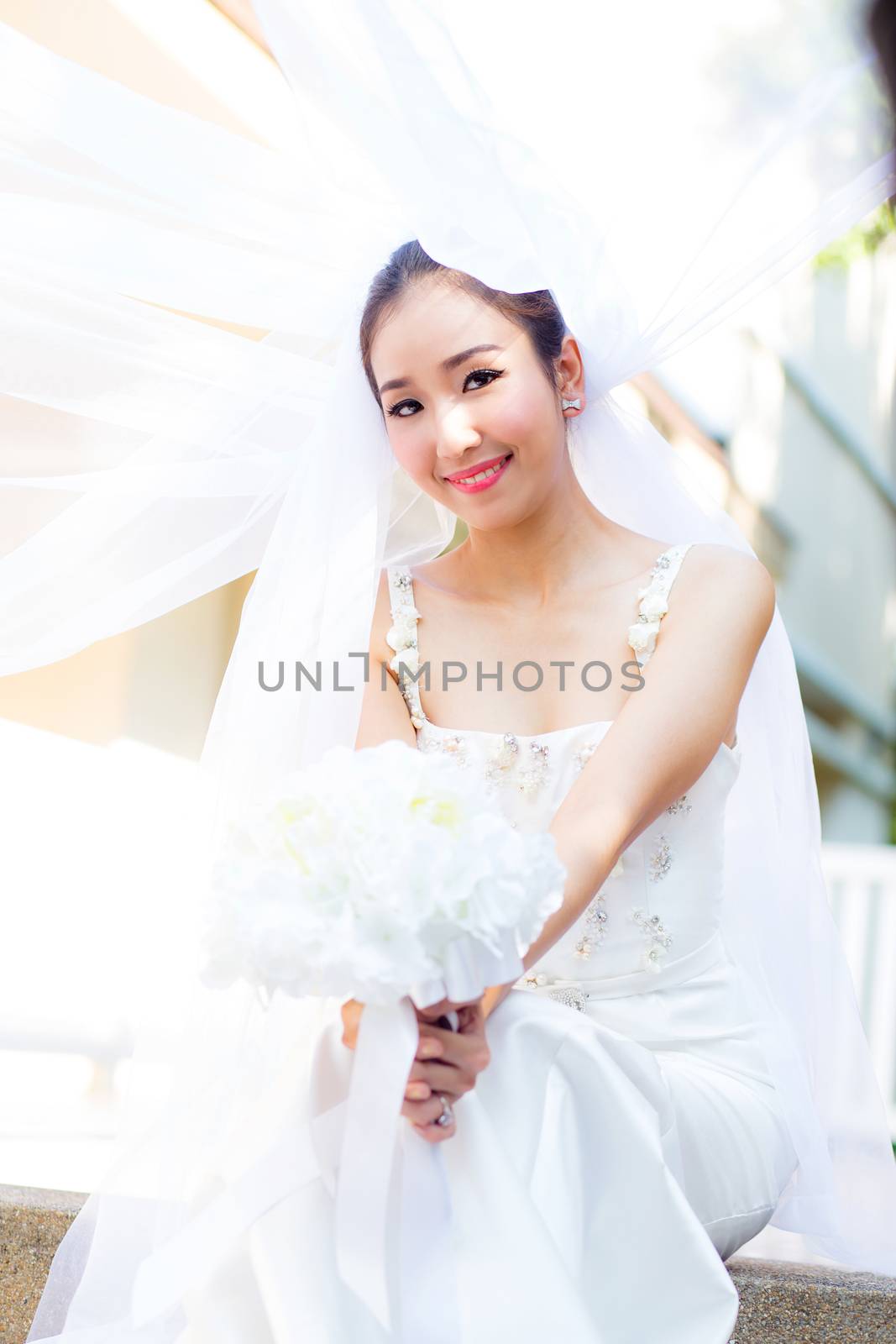 beautiful young woman on wedding day in white dress in the garde by nnudoo