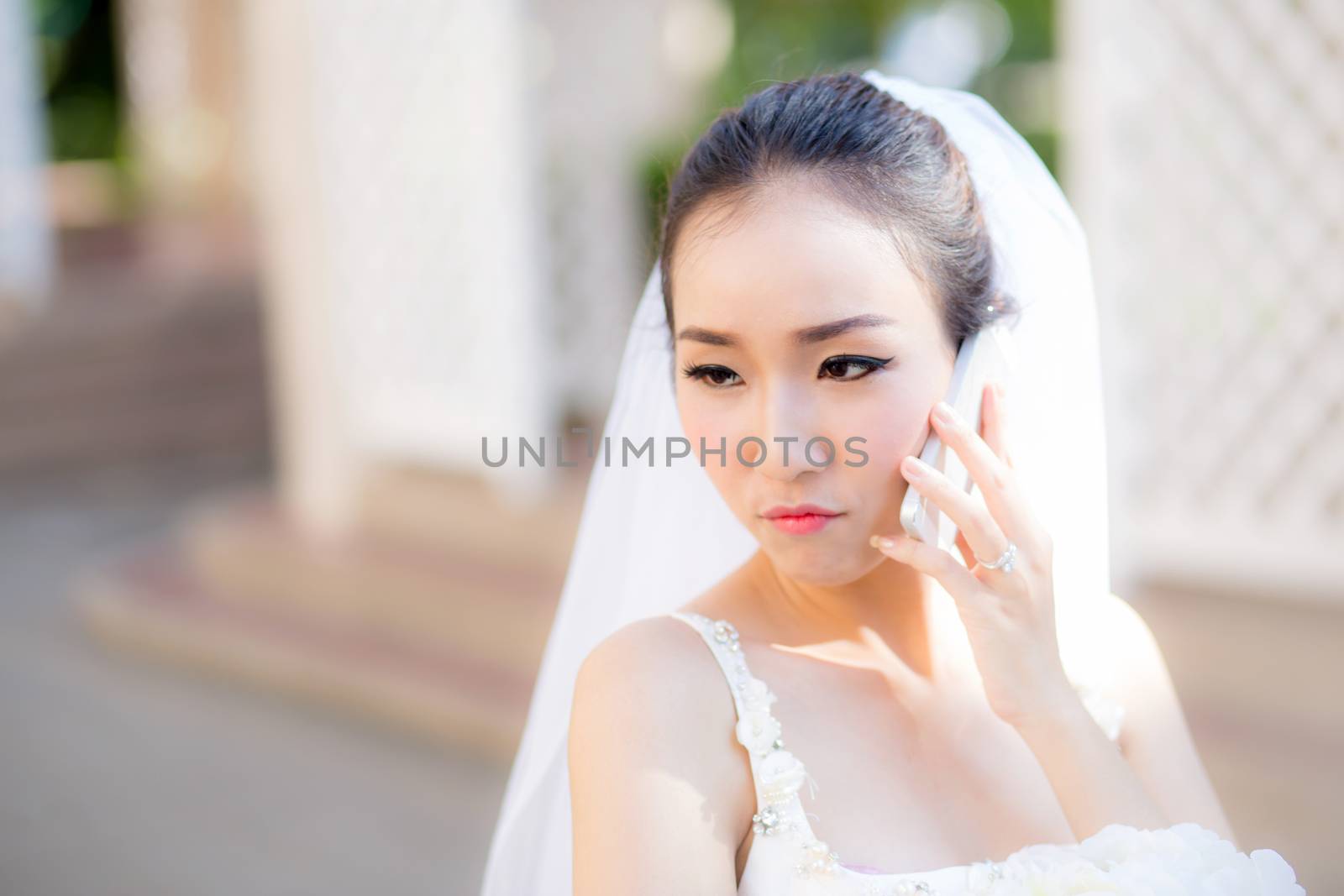 bride talking on cell phone in wedding dress