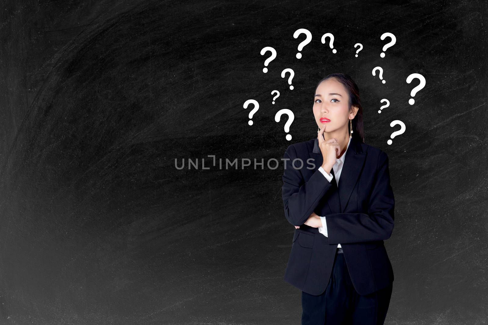 woman is standing with question marks blackboard background