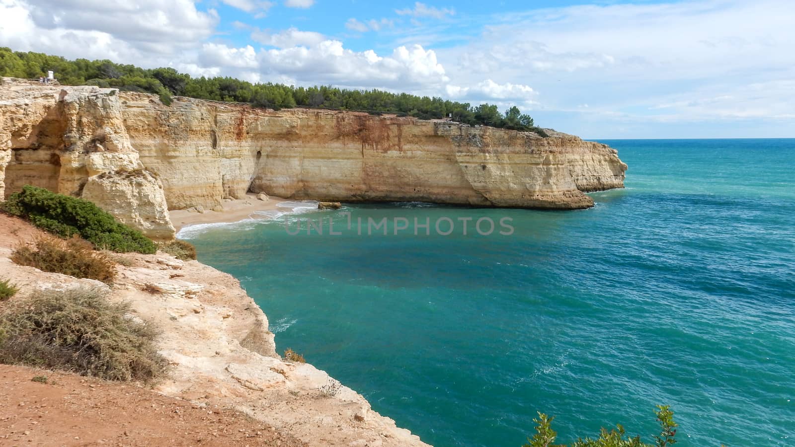 Panoramic view of the ocean cliffs of the Algarve, Portugal, with cloudy blue sky by robbyfontanesi