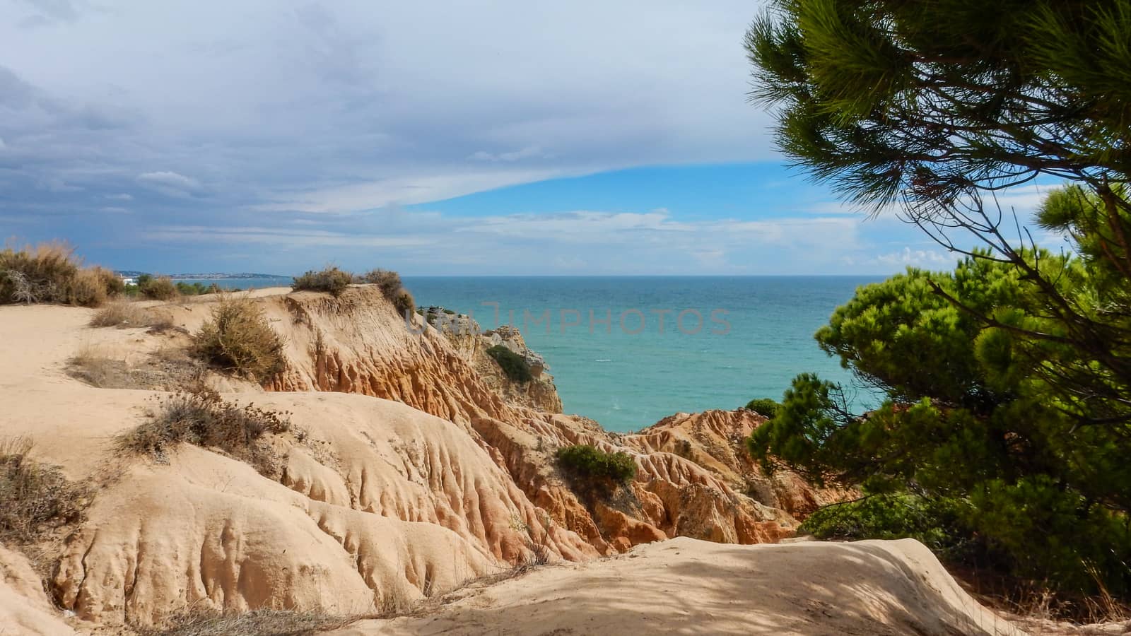 Panoramic view of the Algarve ocean cliffs, Portugal, with cloudy dramatic sky