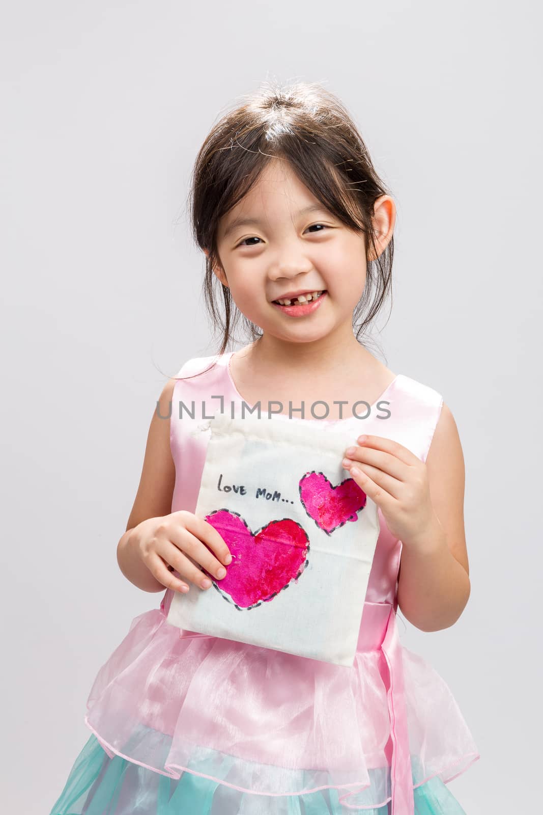 Cute Asian girl showing LOVE MOM message, studio isolated white background.